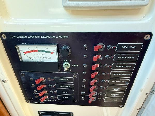 Control panel of a 1978 Dyer 29 Trunk Cabin boat with various switches and battery monitor.