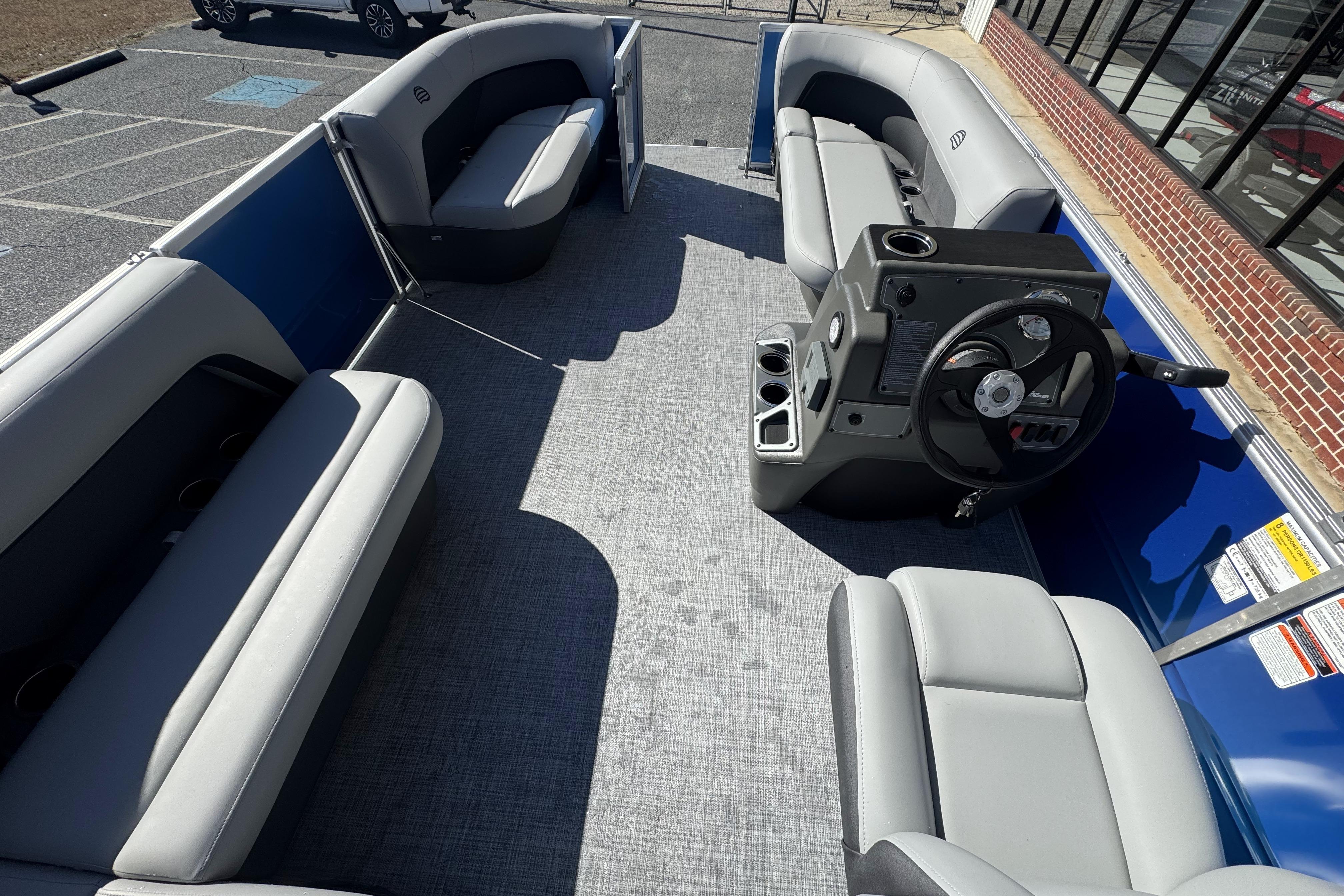 2026 Sun Tracker Party Barge 16 DLX interior with seating and steering console.
