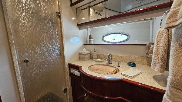 Luxurious bathroom in 2005 Neptunus 56 Flybridge yacht with elegant fixtures and porthole window.