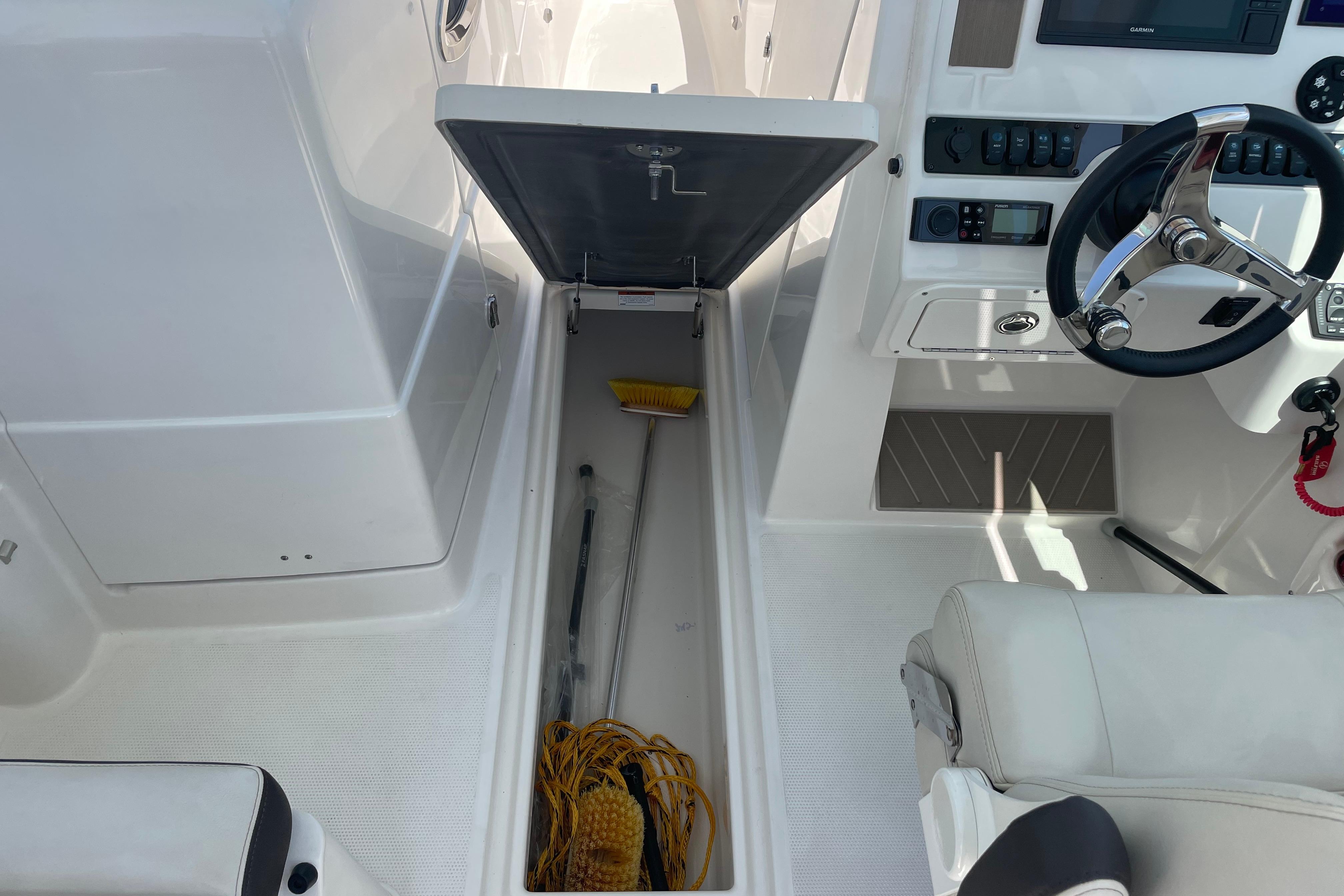 2022 Sailfish 245 DC boat interior with open storage compartment and steering console.