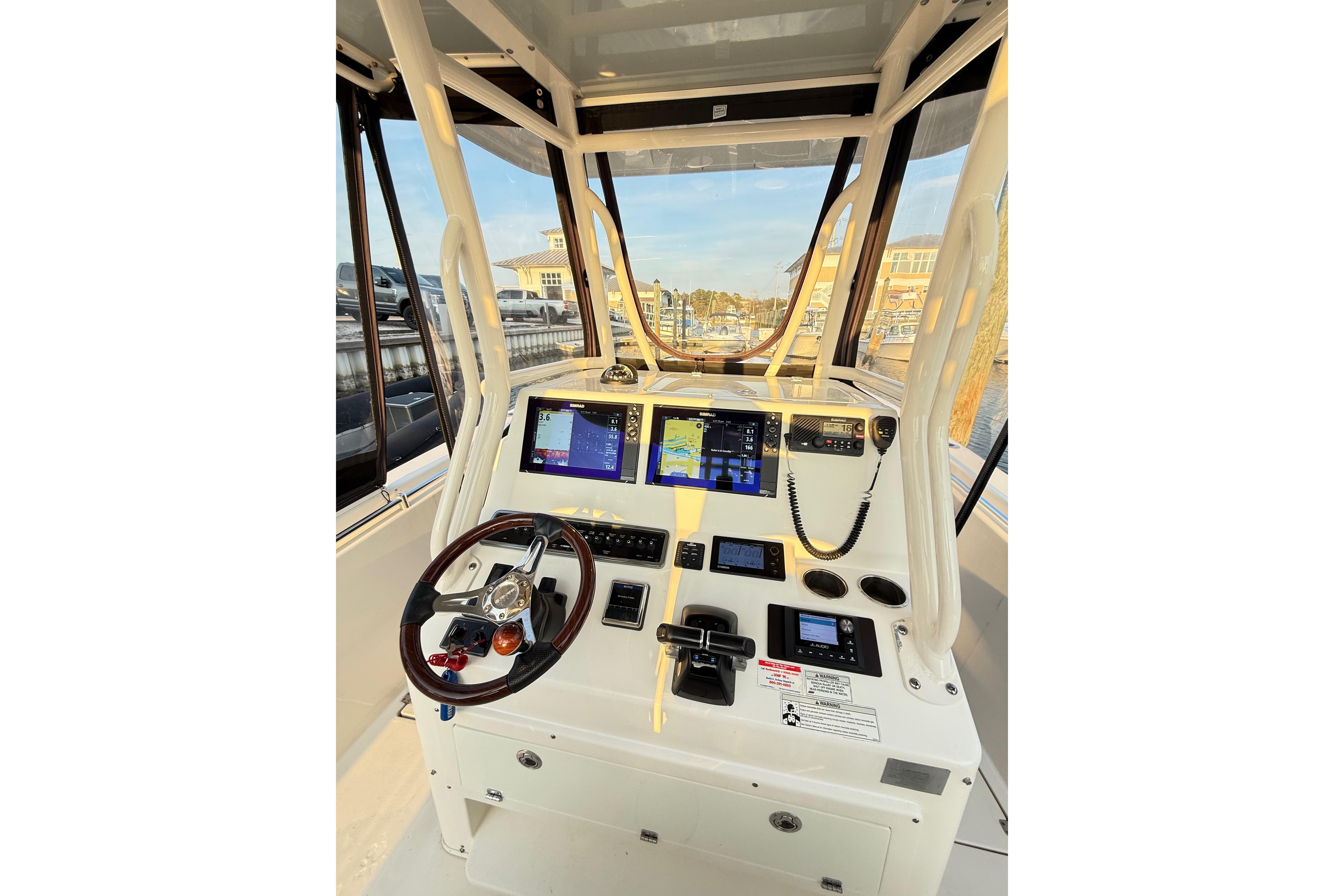 2016 Cobia 296 Center Console boat dashboard with navigation screens and steering wheel.