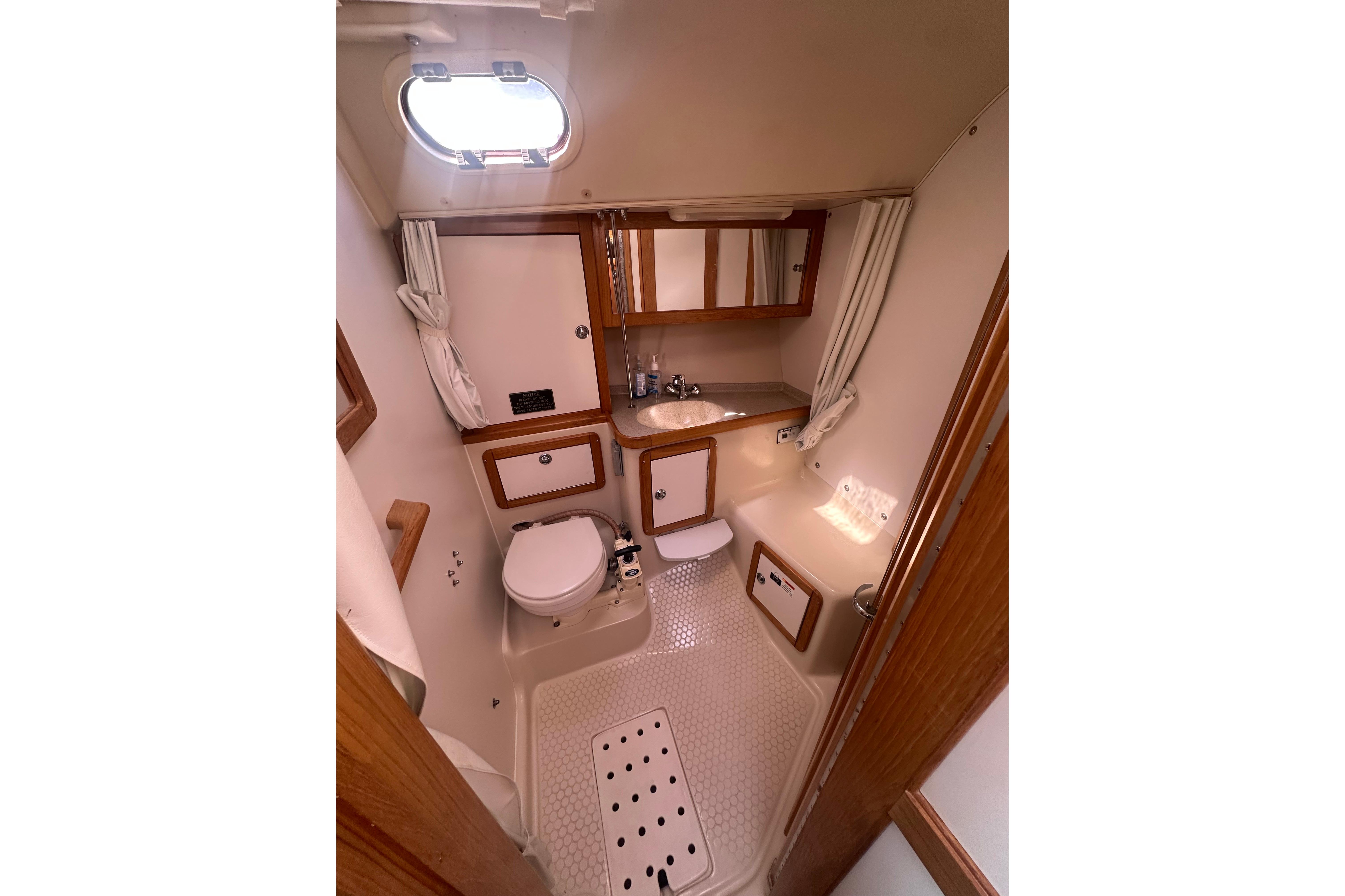 Bathroom interior of 2005 Catalina 36 MkII sailboat, featuring compact design and wooden accents.