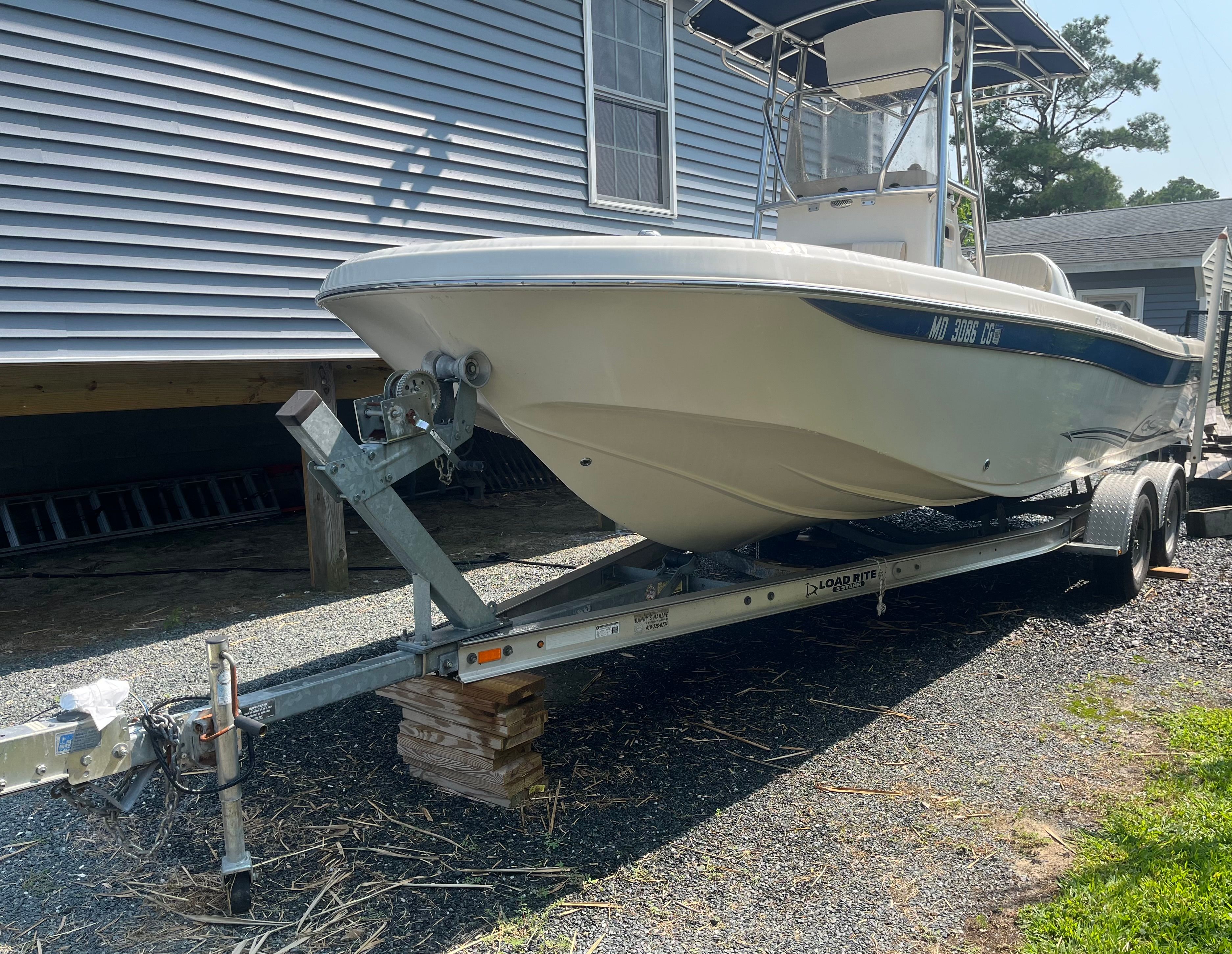 2014 Carolina Skiff 23 Ultra Elite on trailer beside house.