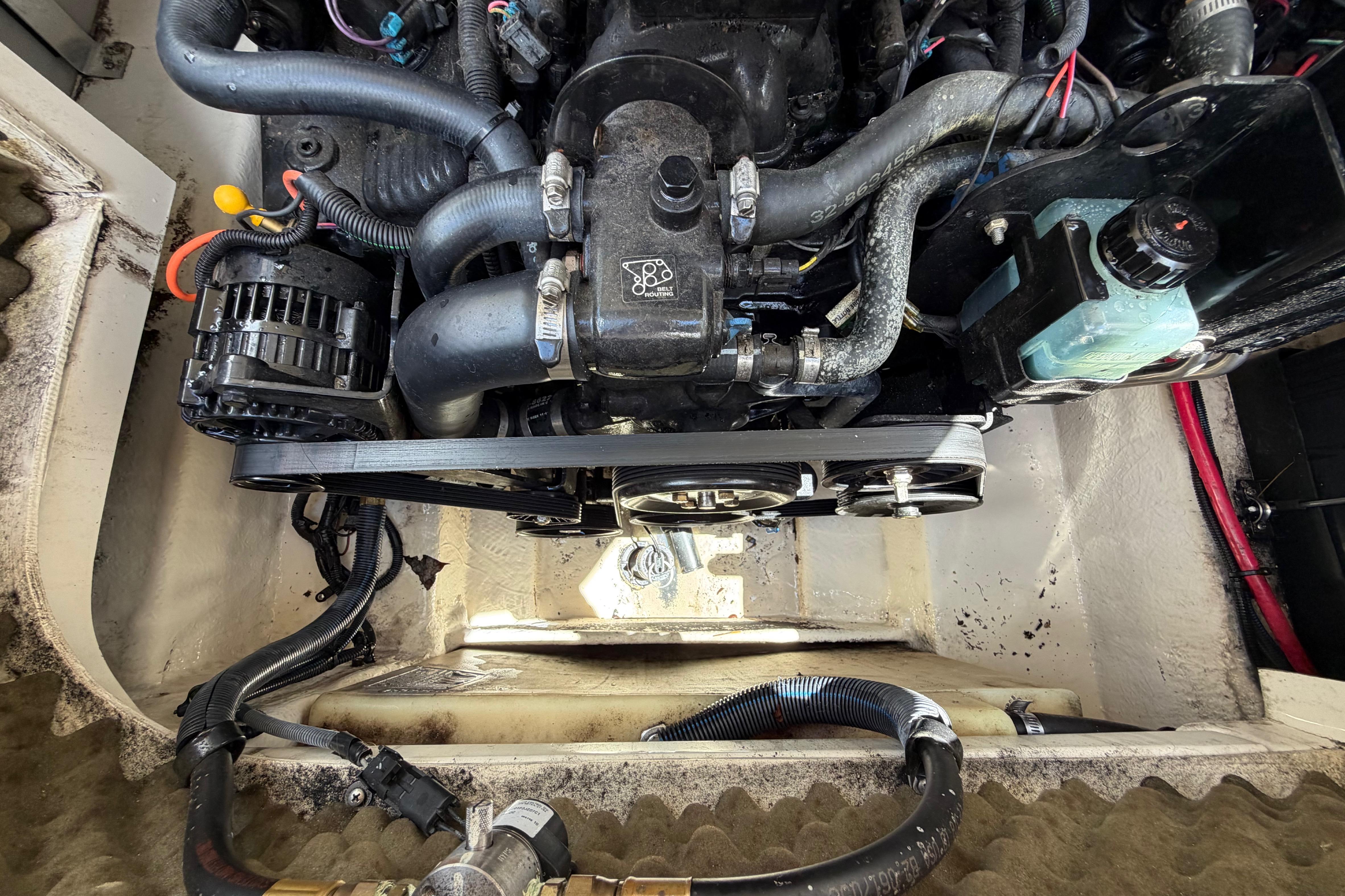 Engine compartment of a 2004 Sea Ray 240 Sundeck, showcasing hoses and components.
