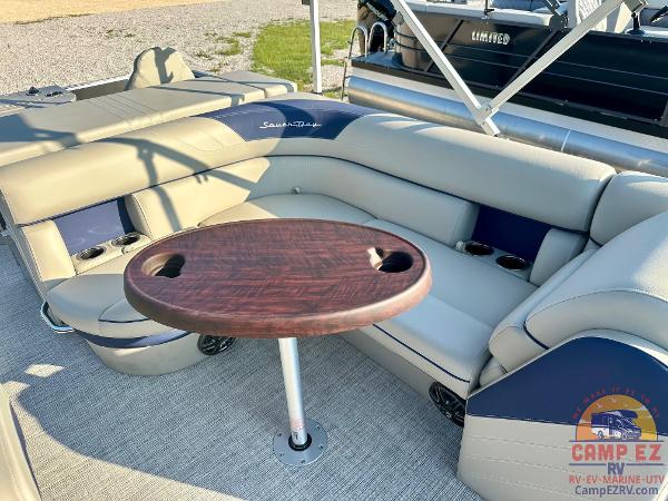 2025 South Bay 224FCR LE pontoon boat interior with cushioned seating and wooden table.