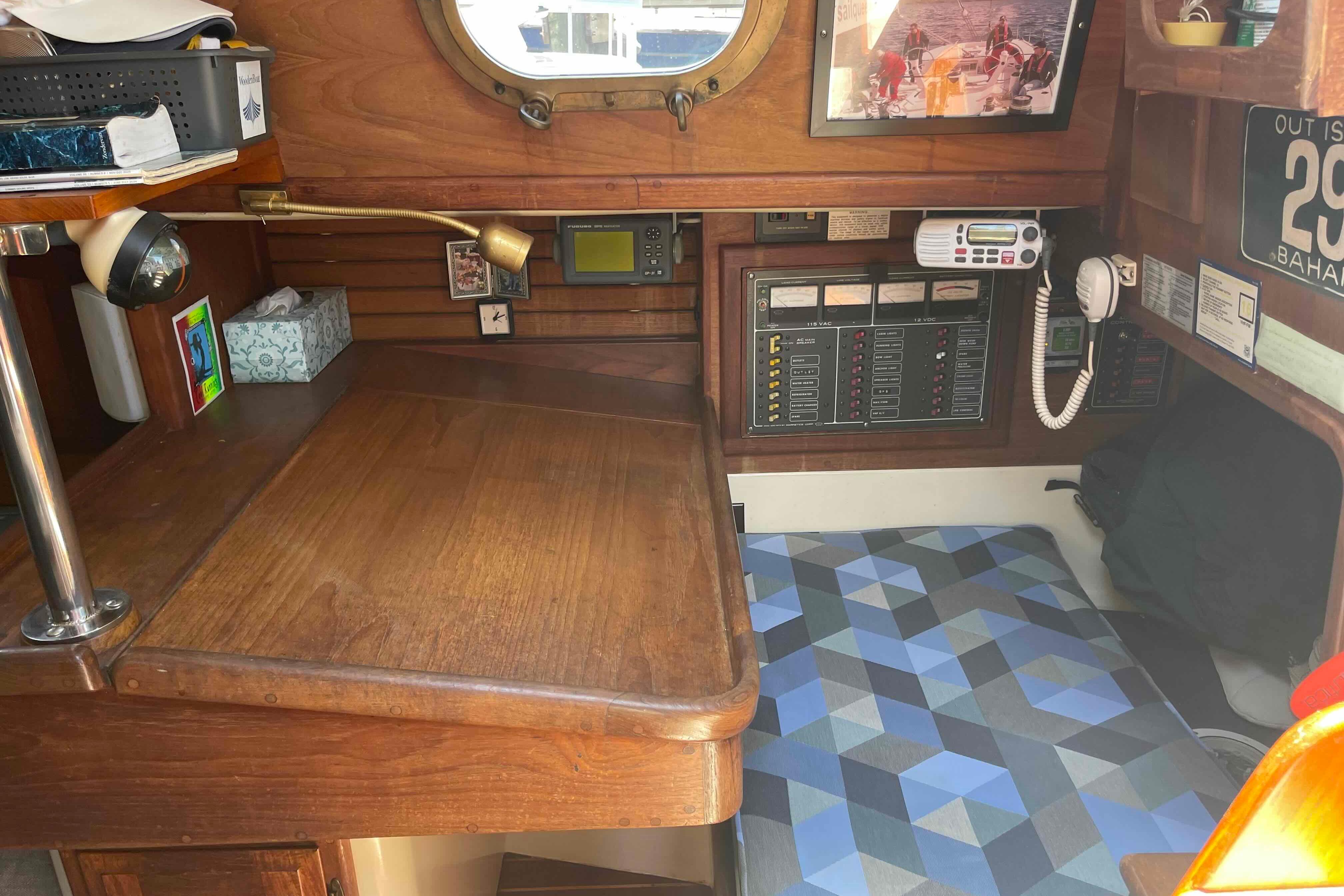 Interior of 1987 Pacific Seacraft 34 sailboat with navigation station and cozy seating area.