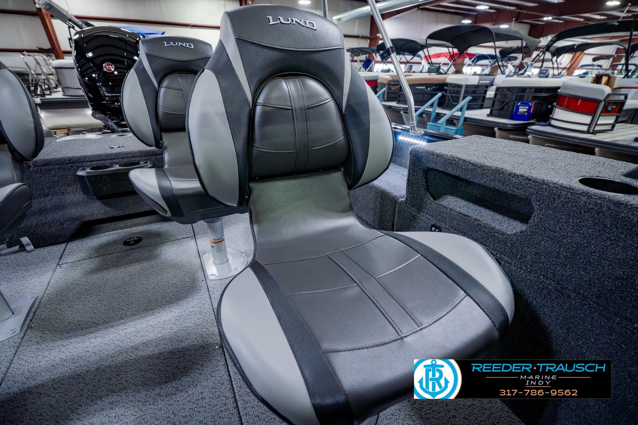 2026 Lund 1875 Impact XS boat interior with sleek black seating in showroom.