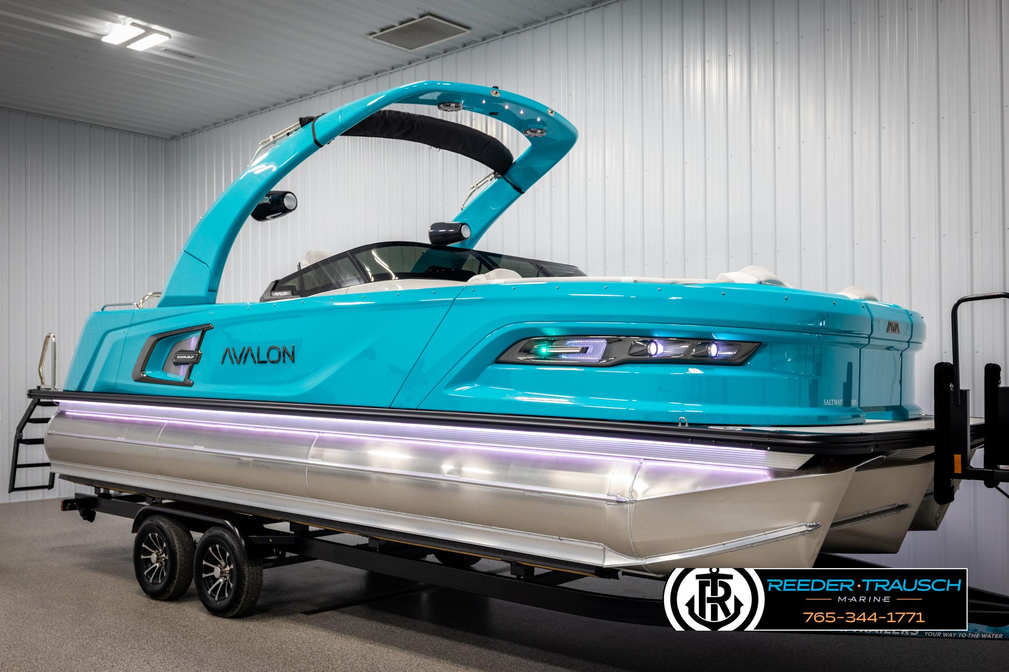 2025 Avalon 2585 Excal VRBW pontoon boat in a showroom, vibrant turquoise color.
