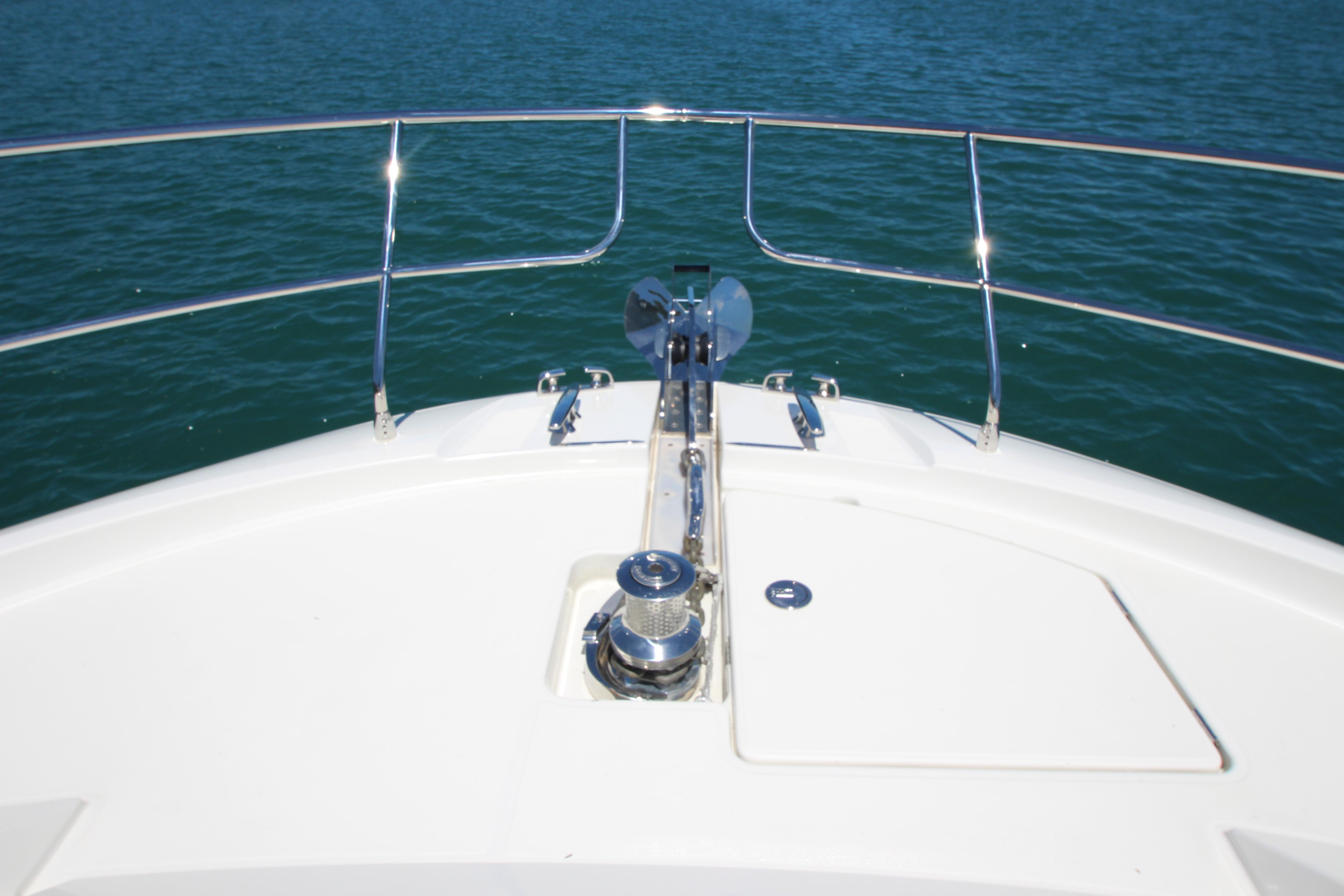 Bow of a 2022 Prestige 520 yacht with stainless steel railings on blue water.