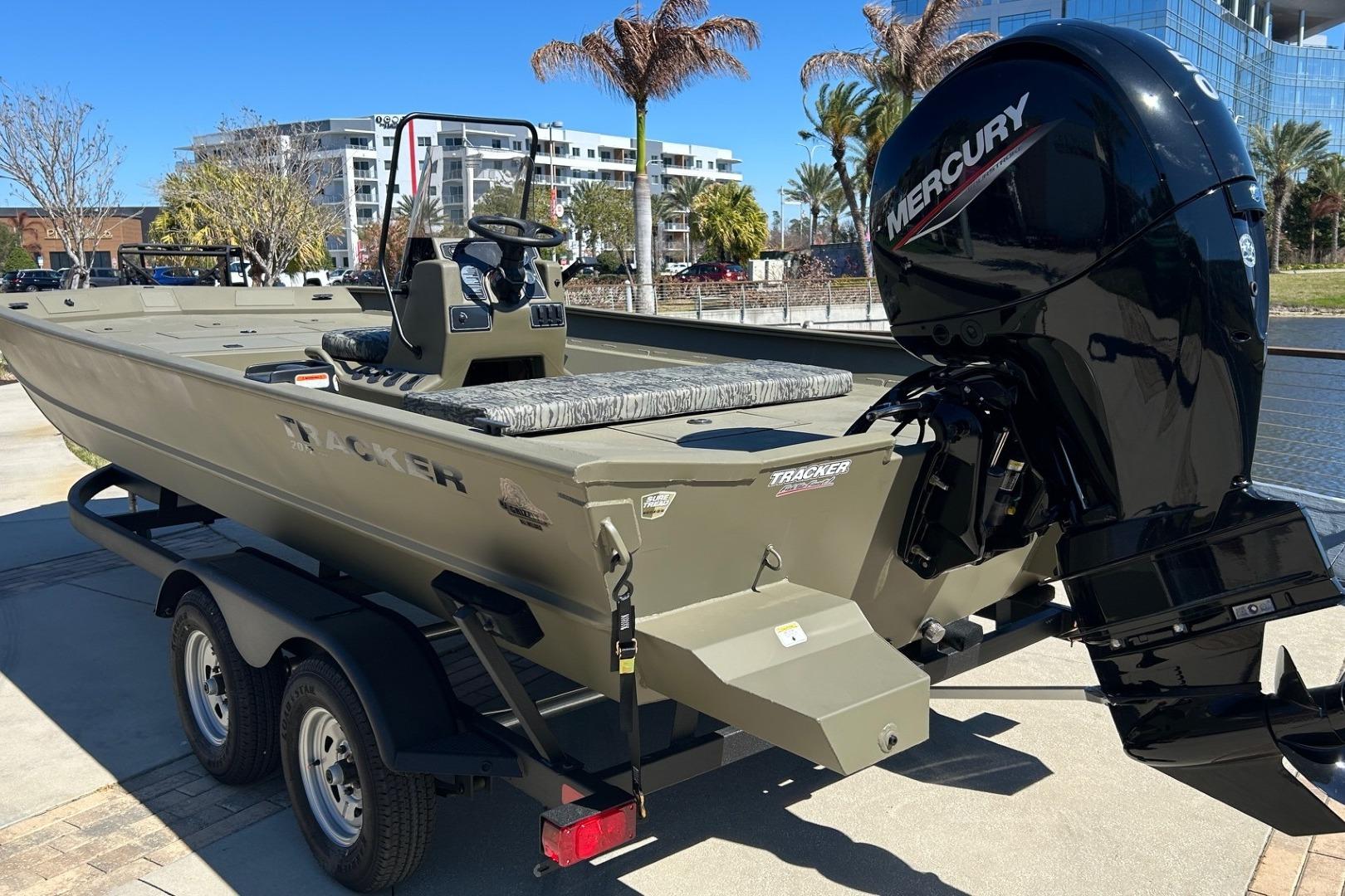 2026 Tracker Grizzly 2072 CC boat with Mercury engine on trailer, outdoor setting.