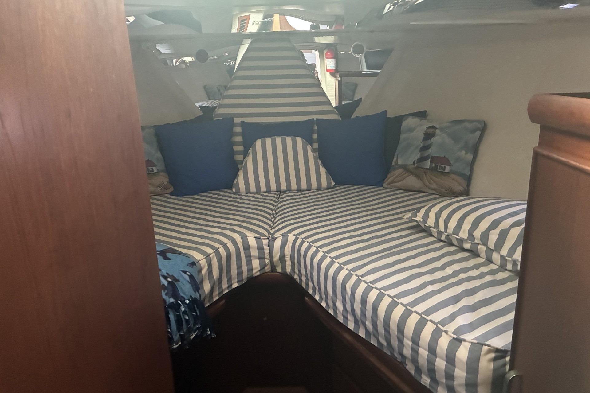 Interior cabin of 1980 Chris-Craft 360 Commander with striped bedding and nautical decor.
