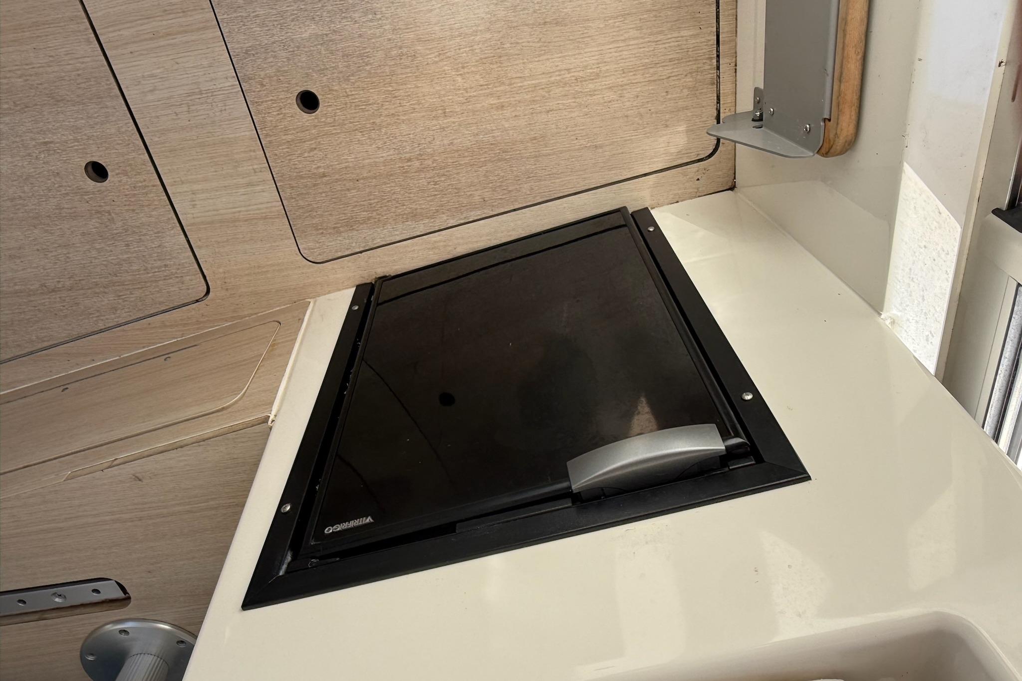 2024 Bayliner Trophy T25 Pilothouse interior with closed hatch and wooden paneling.
