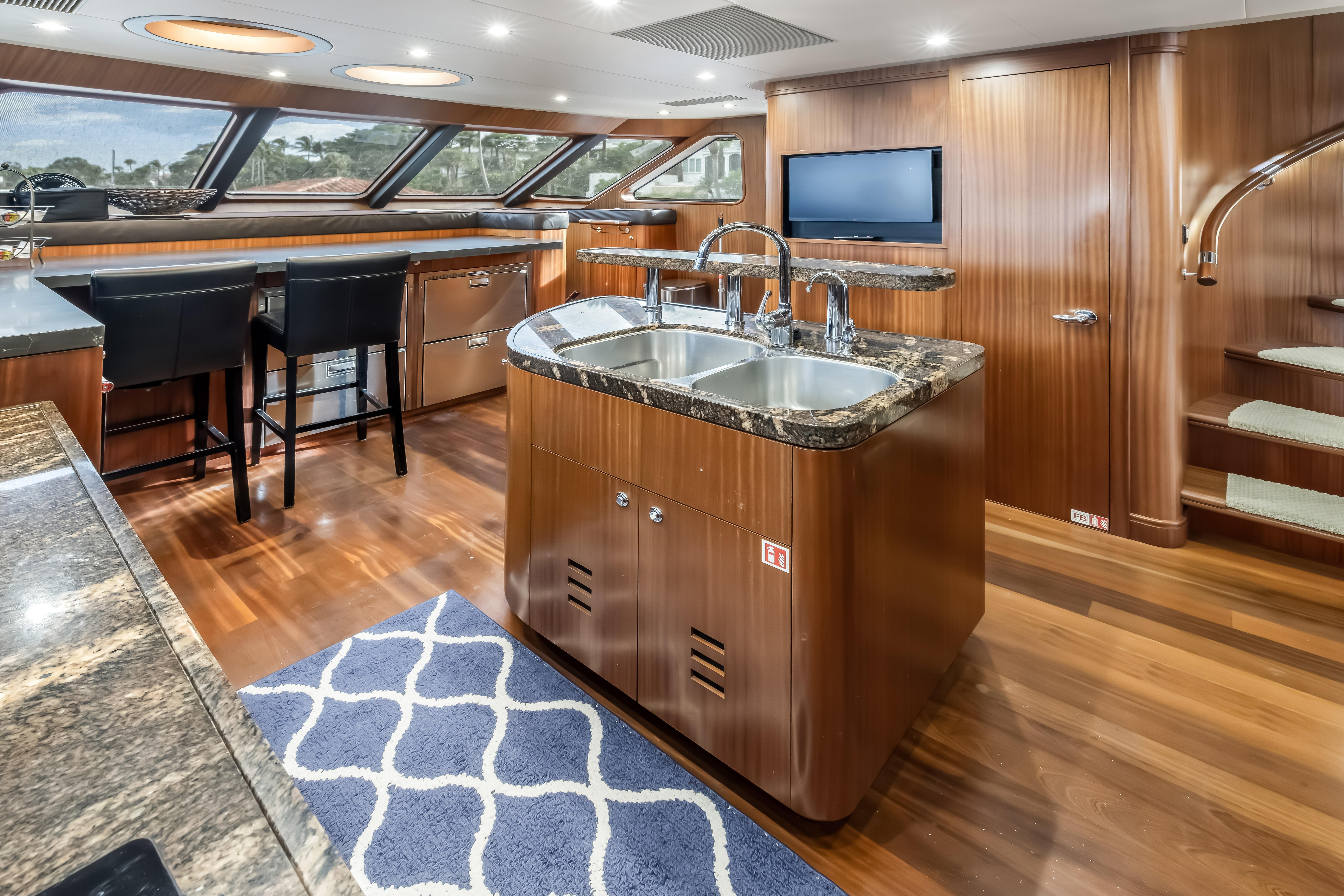 Luxurious 2012 Cheoy Lee 84 Bravo yacht interior with modern kitchen and elegant wood finishes.