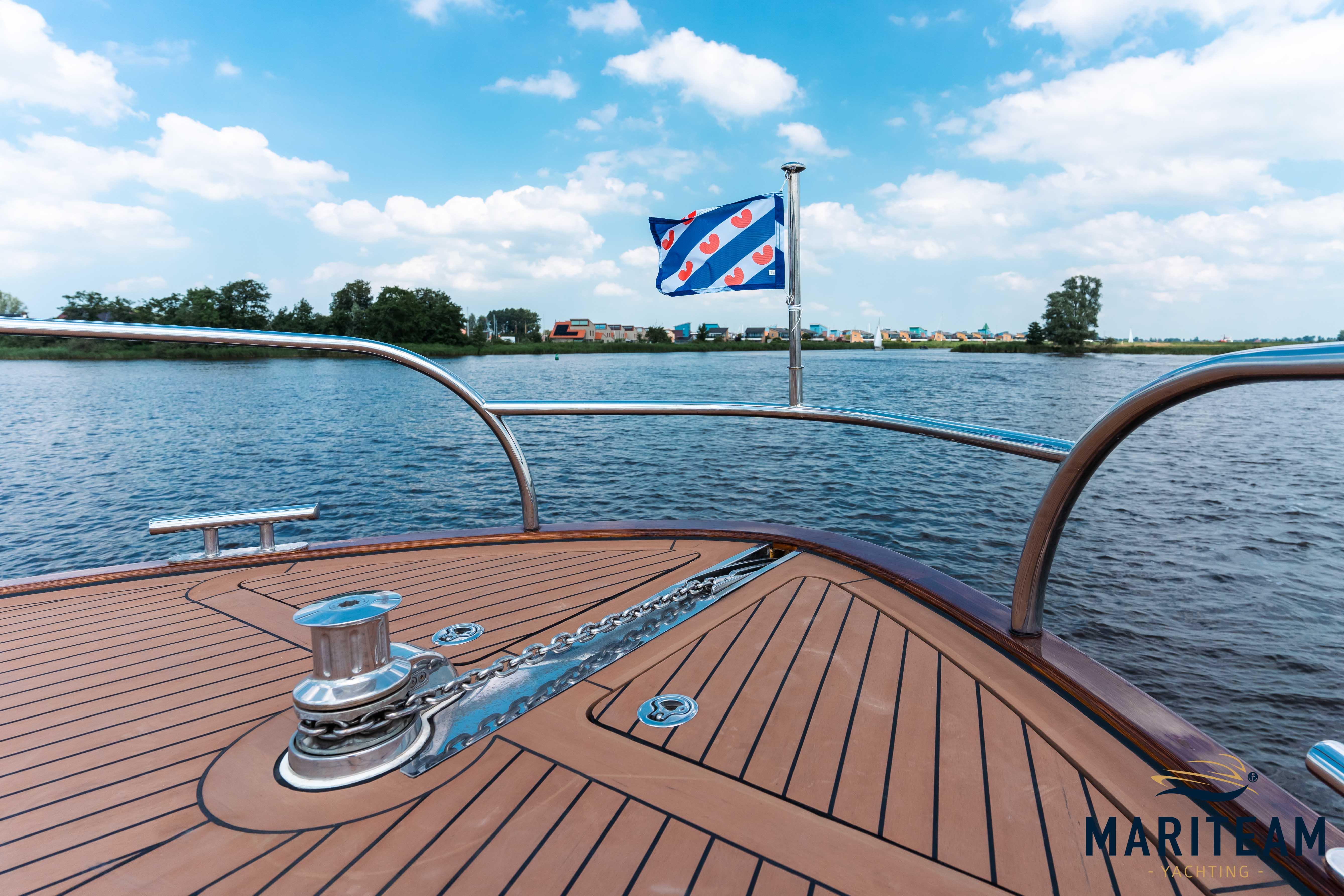 Bow view of 2017 Breedendam MTB fourzero Wheelhouse on water, featuring wooden deck and flag.