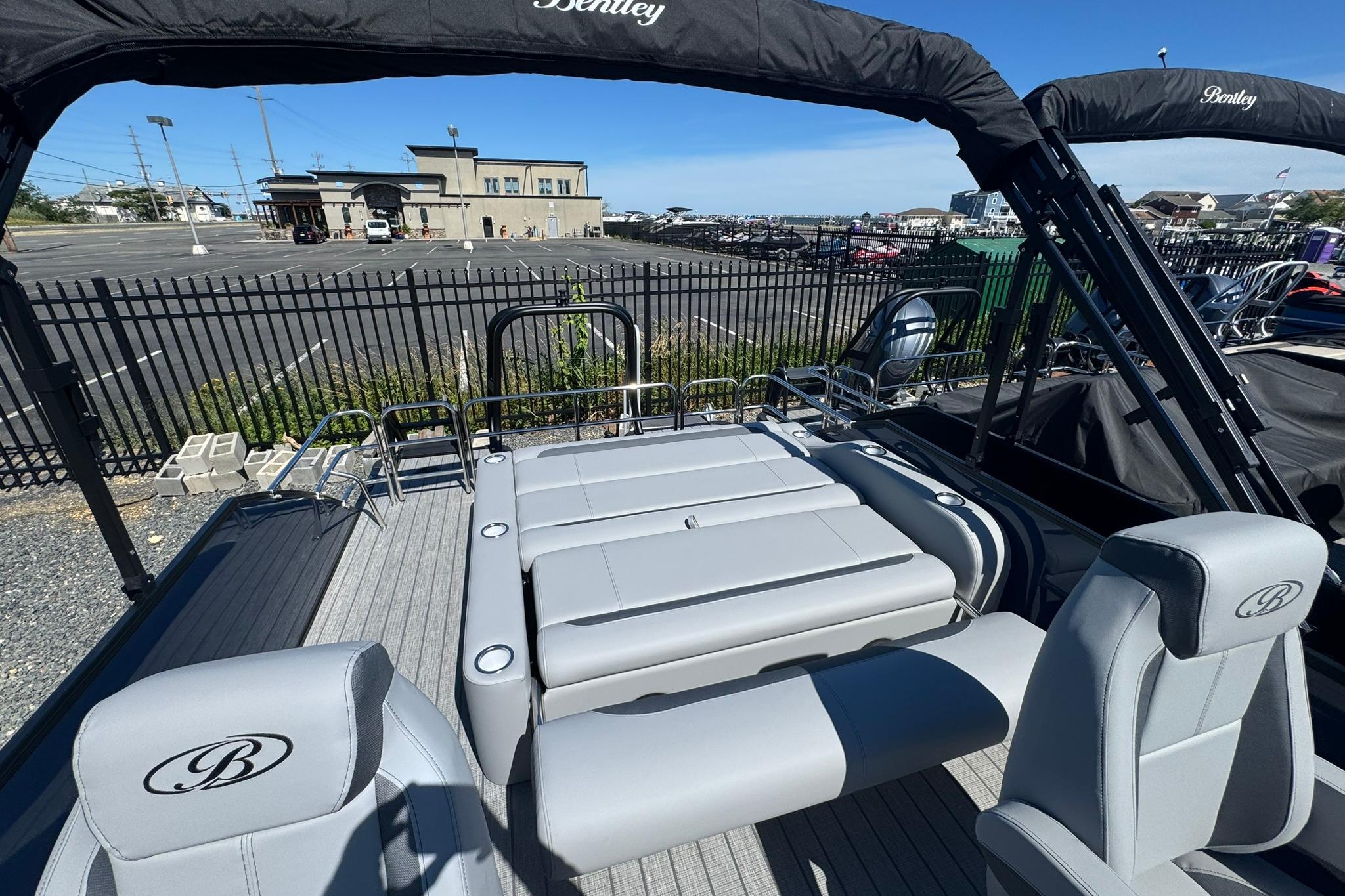 2026 Bentley Pontoons Legacy 243 Swingback with luxurious seating and sleek design in a marina setting.