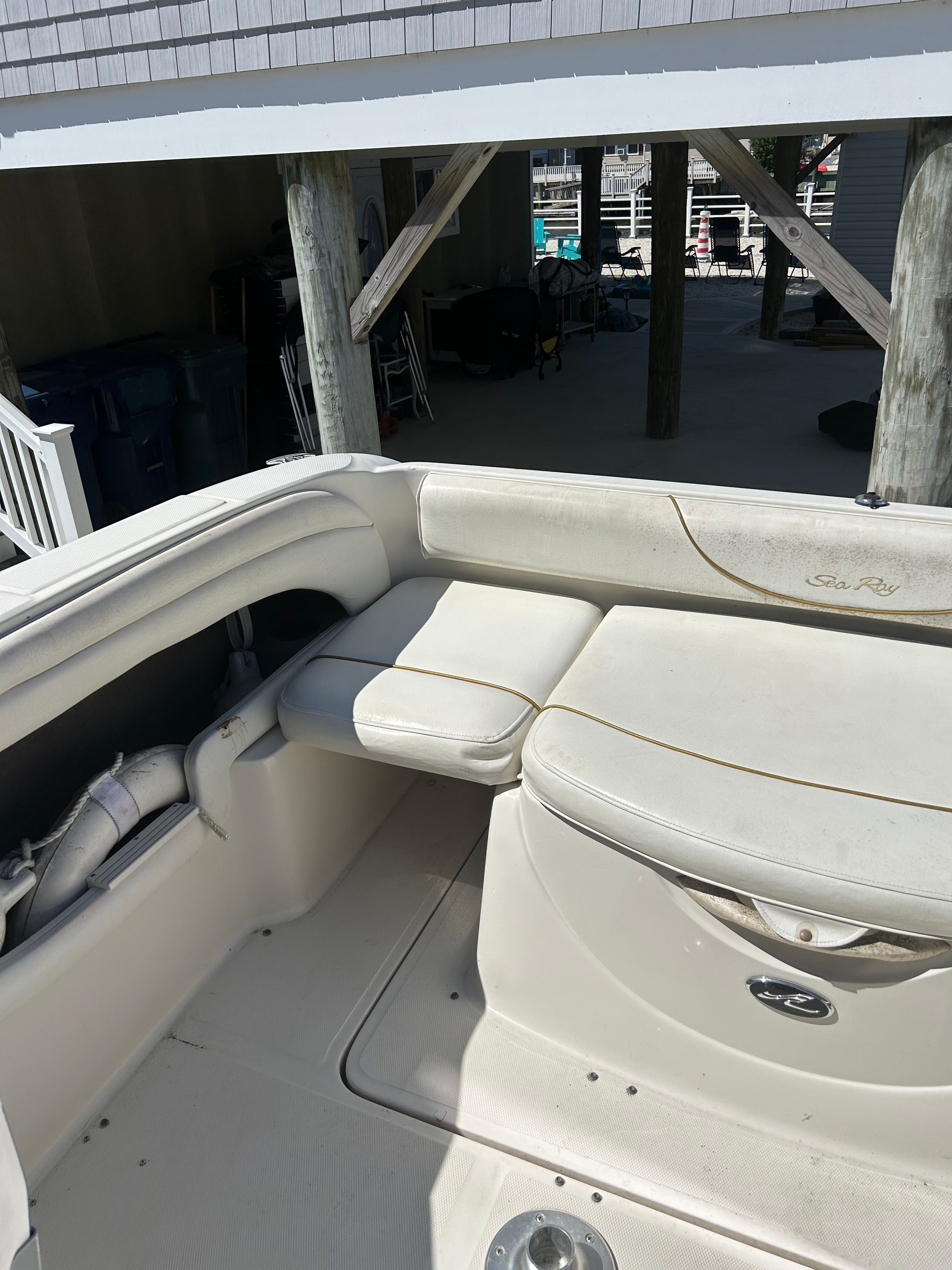 The image shows the cockpit of a 2002 Sea Ray 225 Weekender with white upholstery.
