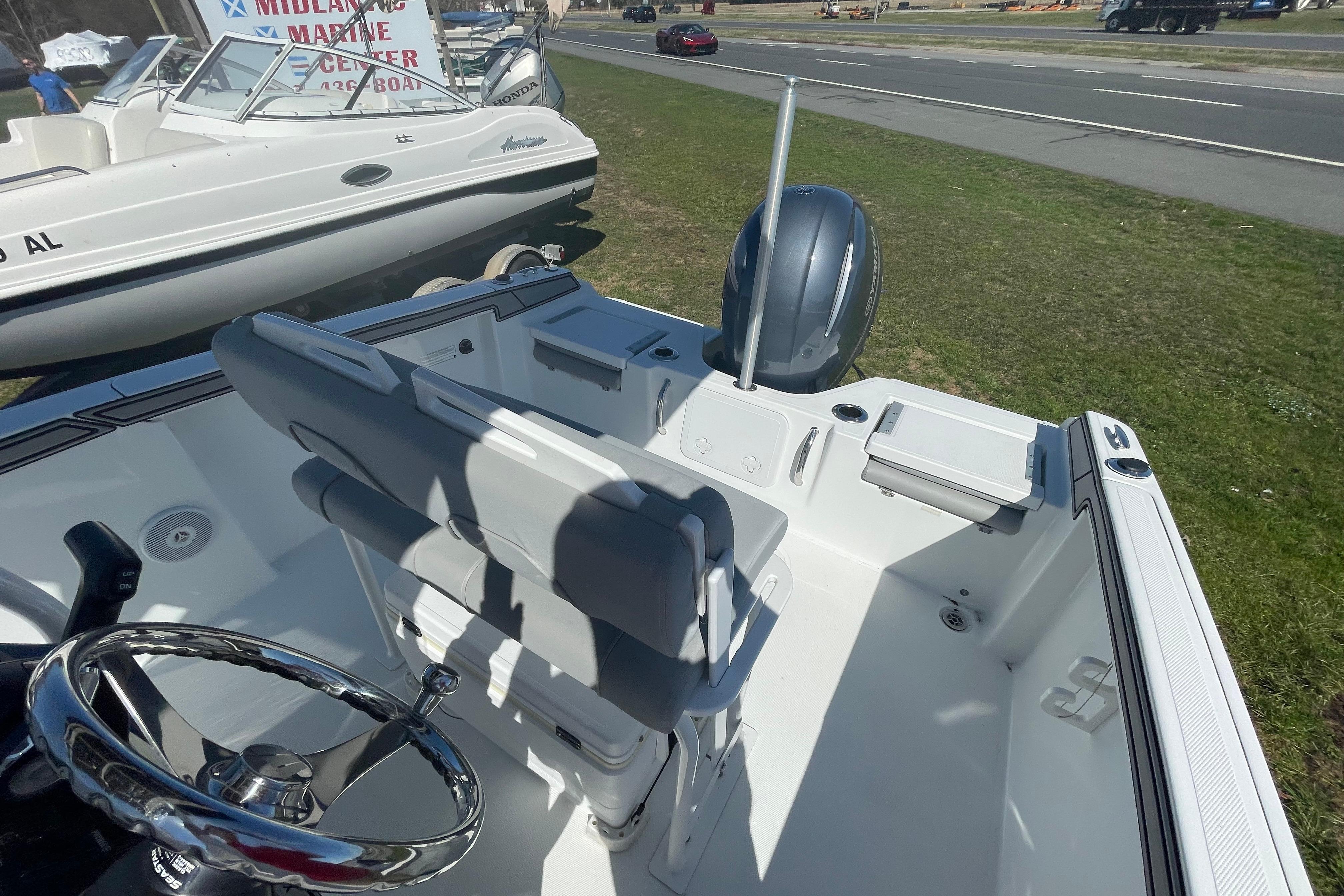 2022 Wellcraft 202 Fisherman boat interior with steering wheel and seating, displayed outdoors.