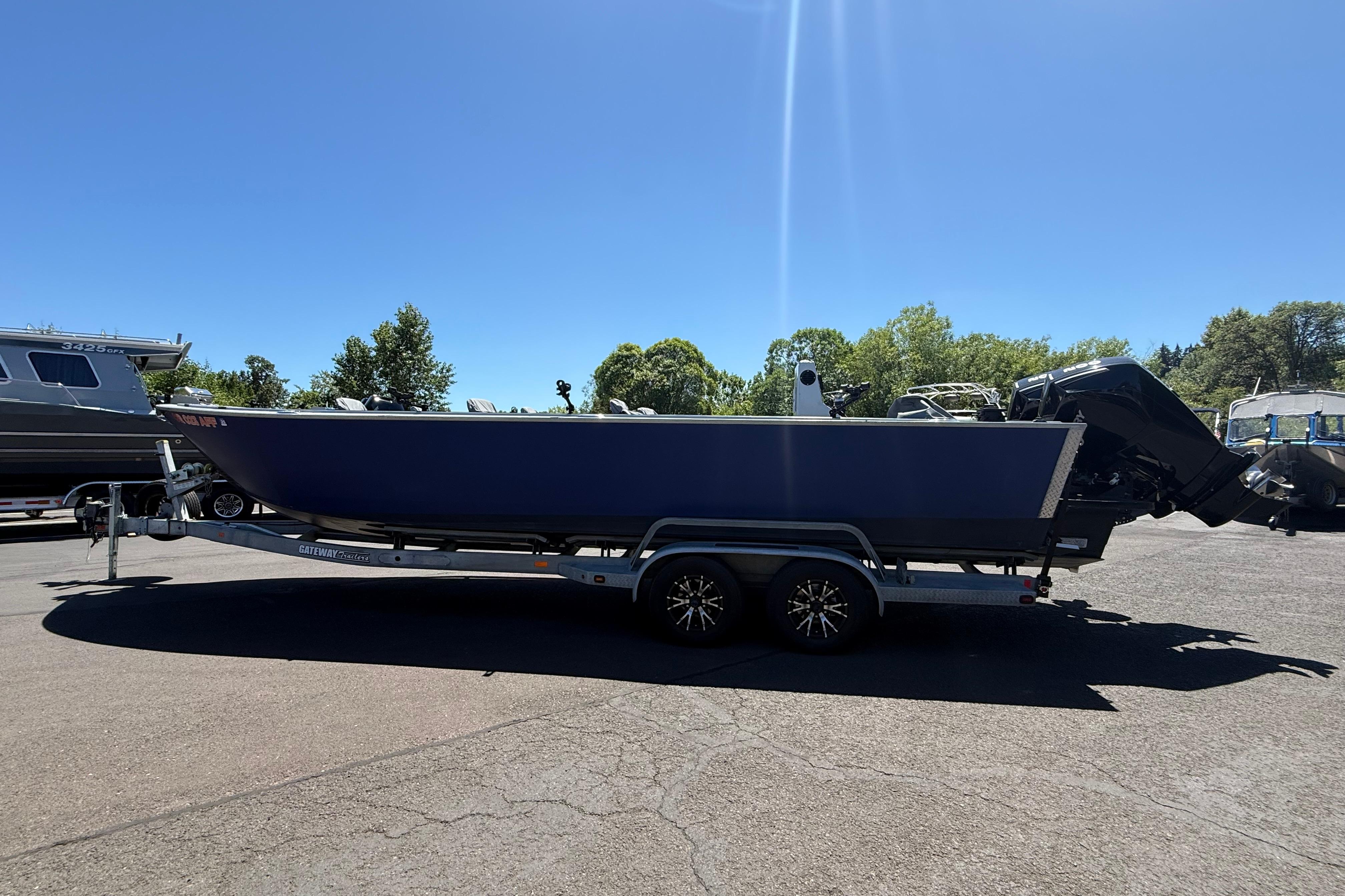 2015 Alumaweld Pacific XD 28 boat on trailer, parked outdoors under clear sky.