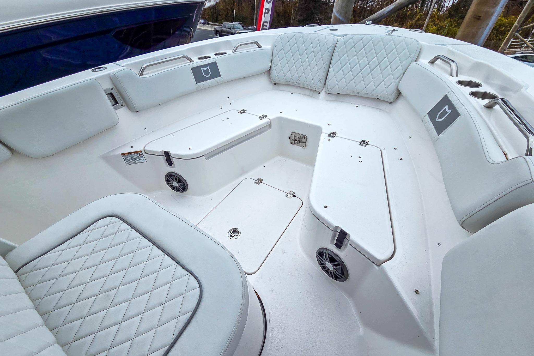Interior of 2026 Sea Fox 228 Commander boat with white cushioned seating and storage compartments.