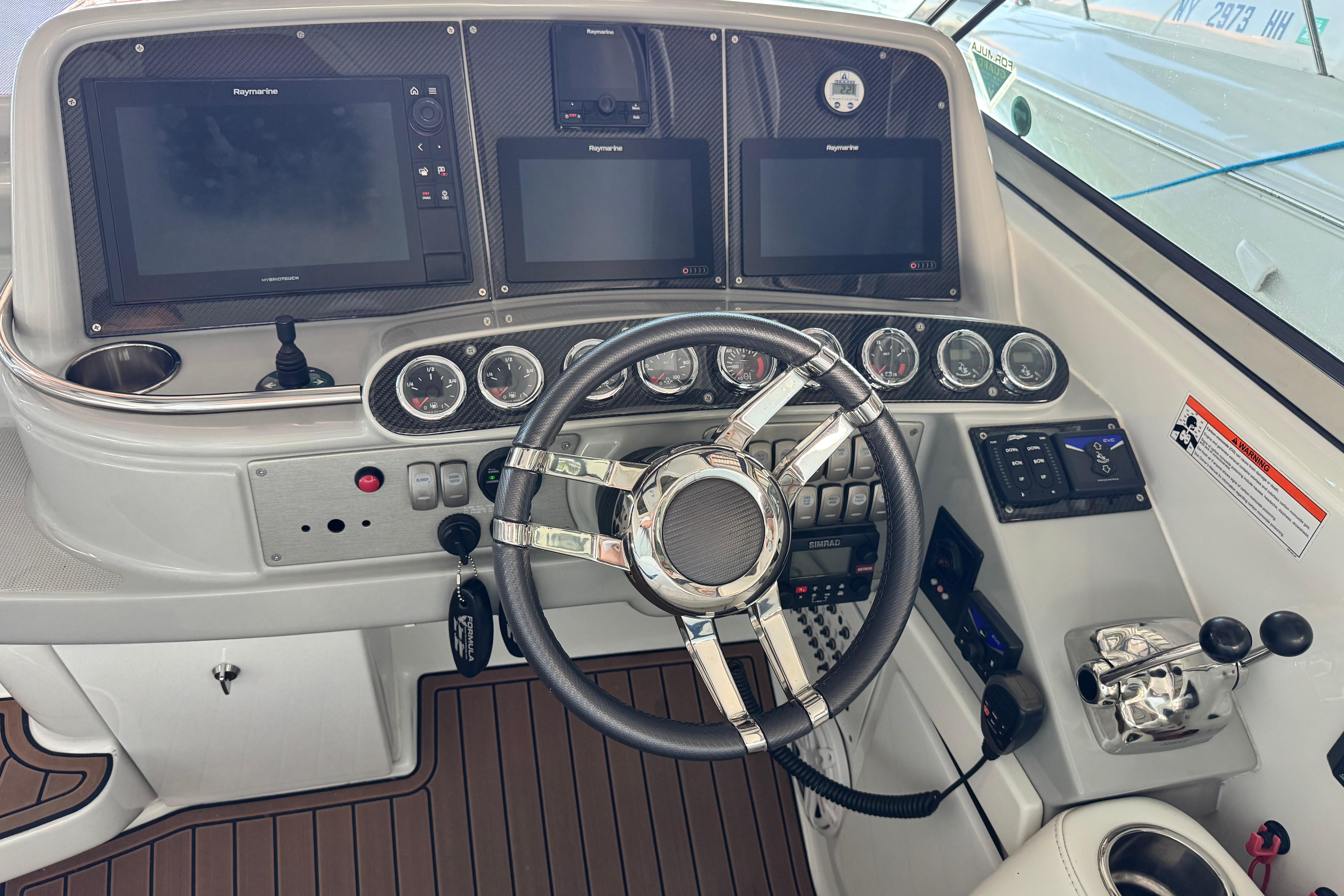 2008 Formula 400 Super Sport boat dashboard with steering wheel and navigation screens.