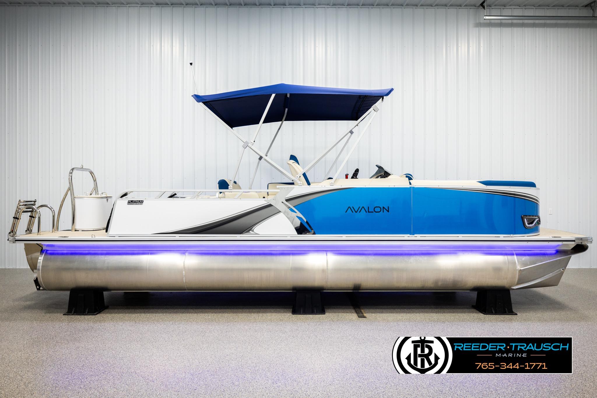 2026 Avalon LSZ VRB pontoon boat with blue canopy and sleek design in showroom.