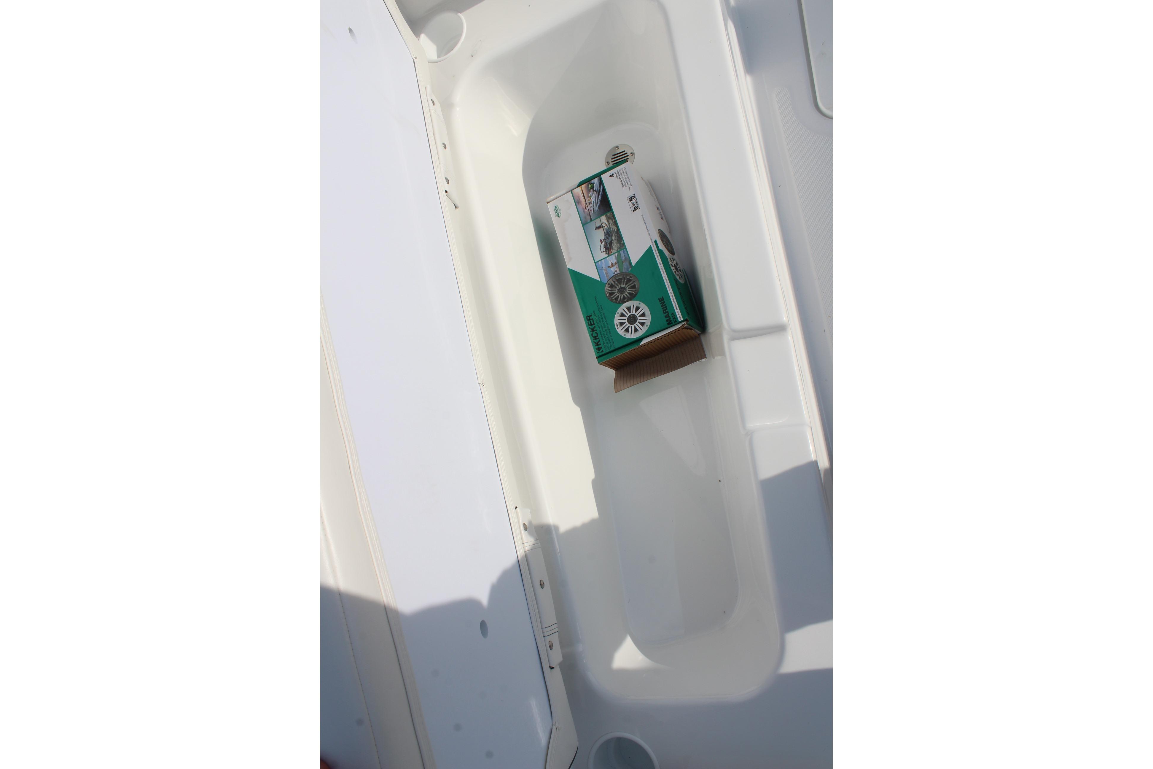 Storage compartment in 2026 Tahoe T18 boat with a boxed item inside.