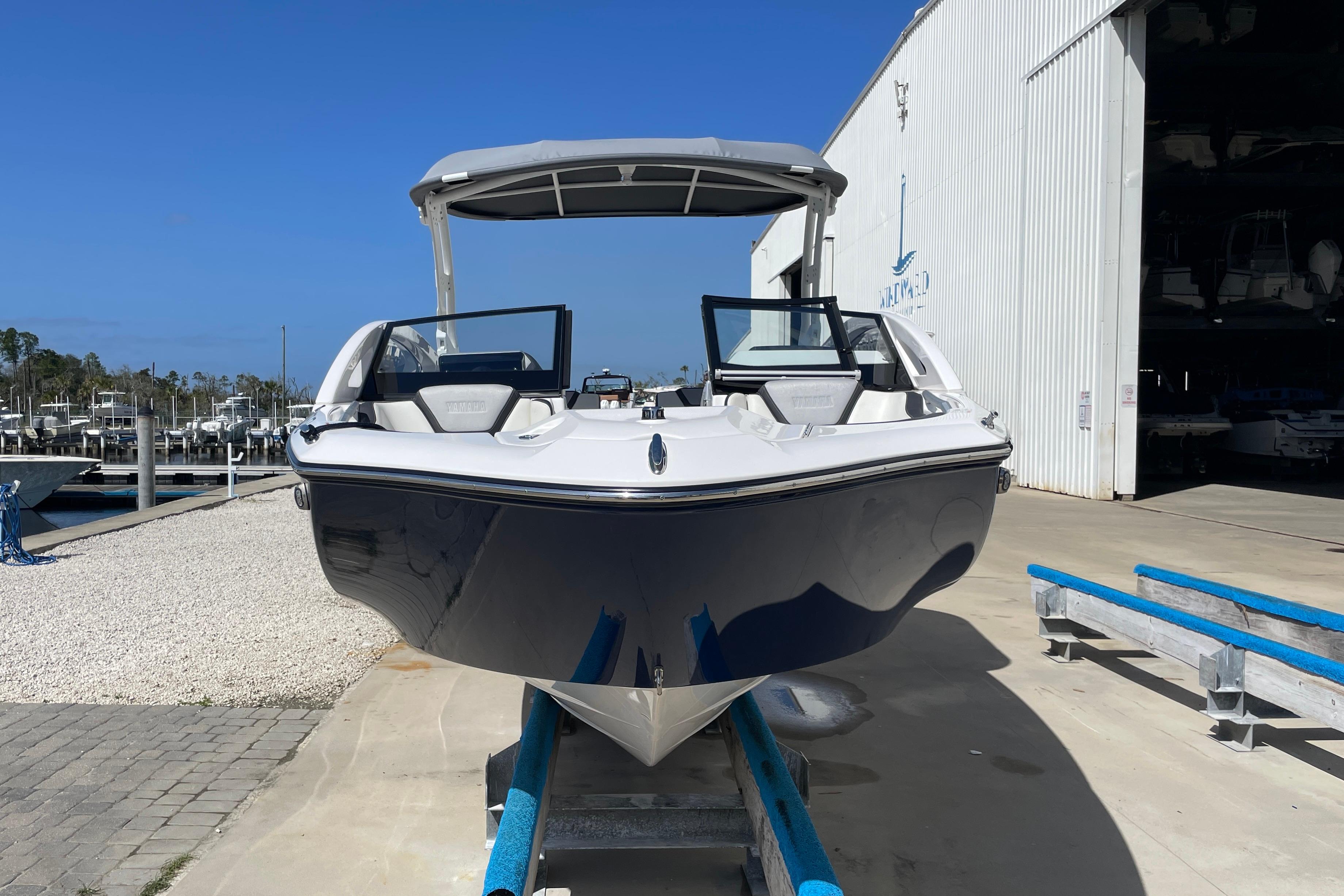 2021 Yamaha Boats 275SE in marina, front view, near storage facility.