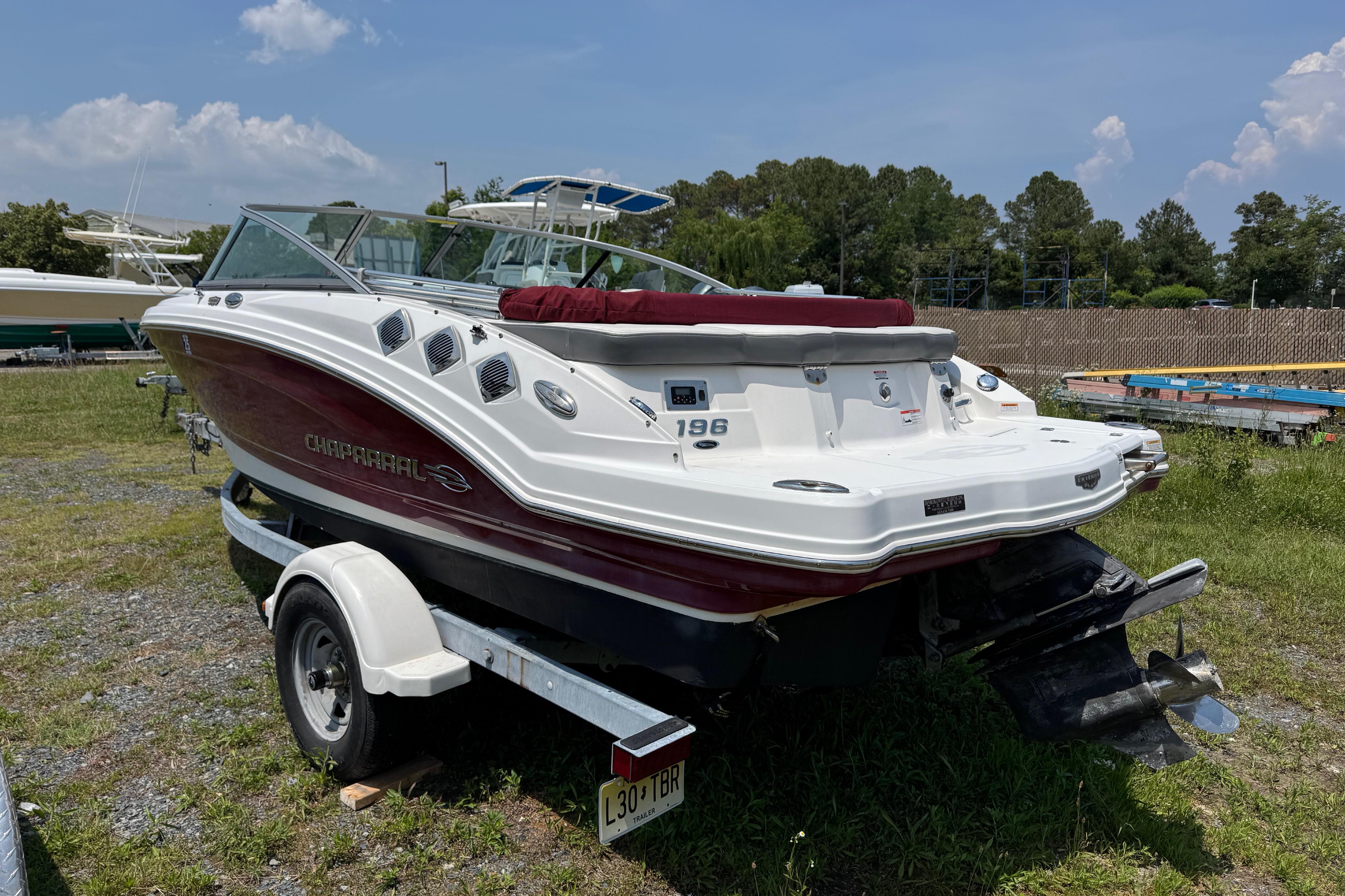 2013 Chaparral 196 SSi boat on trailer, parked on grass under a clear sky.