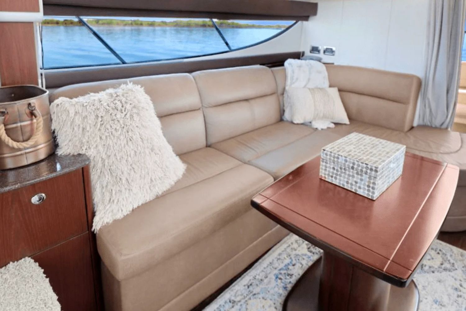 Interior of a 2013 Meridian 391 Sedan yacht with leather sofa and wooden table.