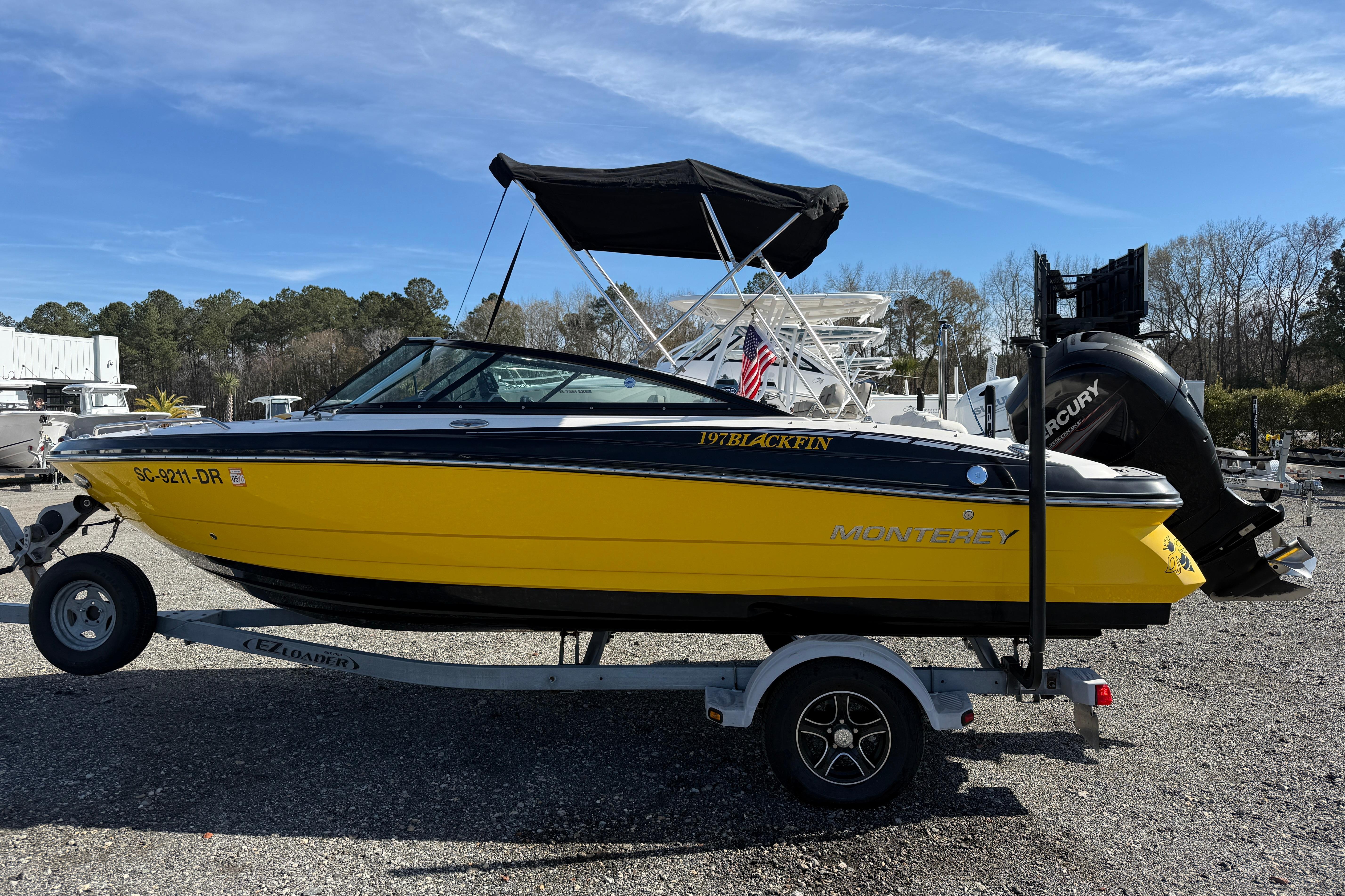 2014 Monterey 197 Blackfin boat on trailer, vibrant yellow hull, outdoor setting.