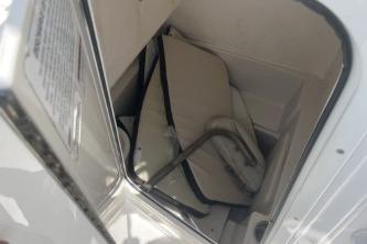 2023 Sailfish 242 CC boat storage compartment with folded seats and metal frame.