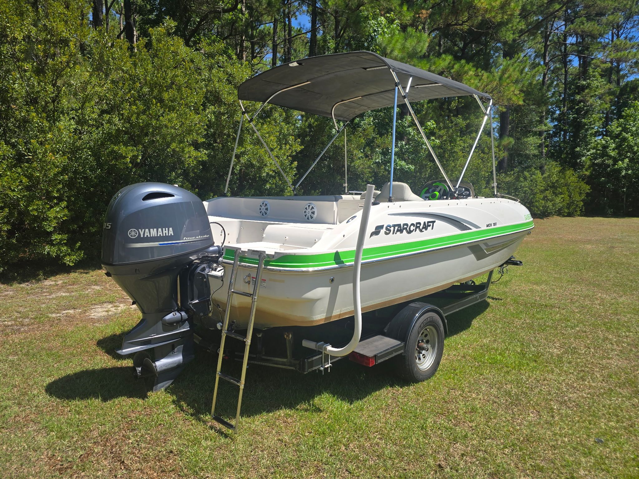 A 2017 Starcraft MDX 191 OB boat on a trailer in a grassy area.