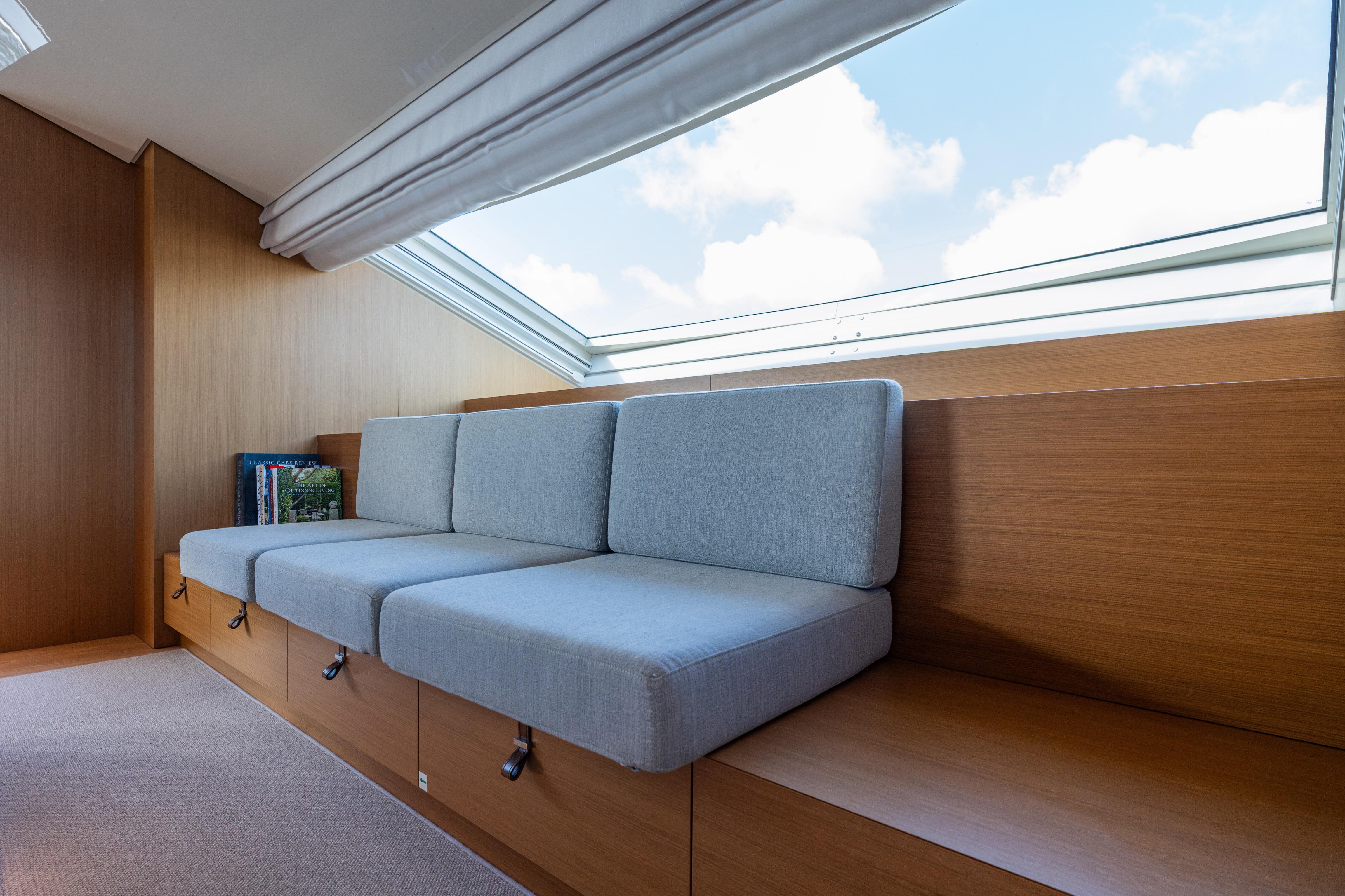 Modern interior of 2023 Sanlorenzo SL120A yacht with sleek seating and large window.