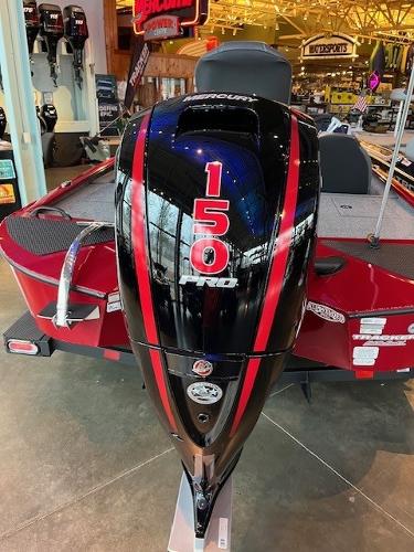 2025 Tracker Savage 215 boat with a 150 Pro outboard motor, displayed indoors.