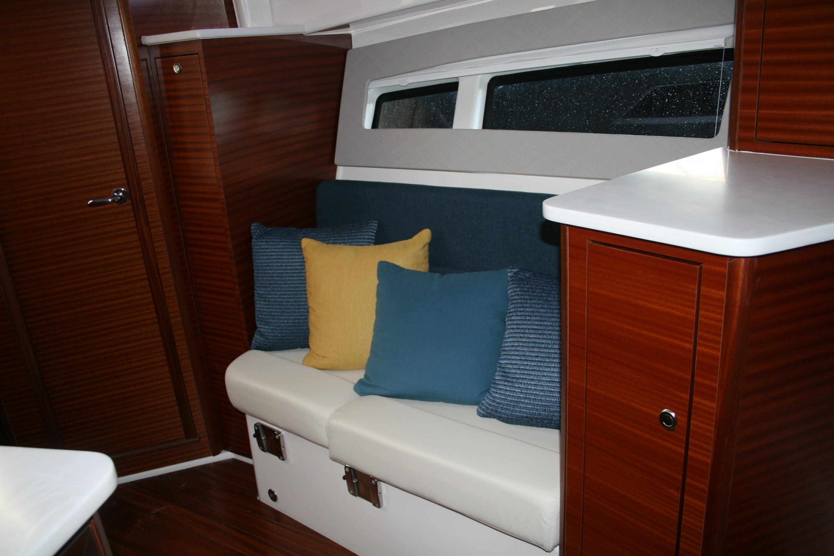 Interior of 2025 Pursuit OS 405 Offshore boat with cozy seating and colorful cushions.