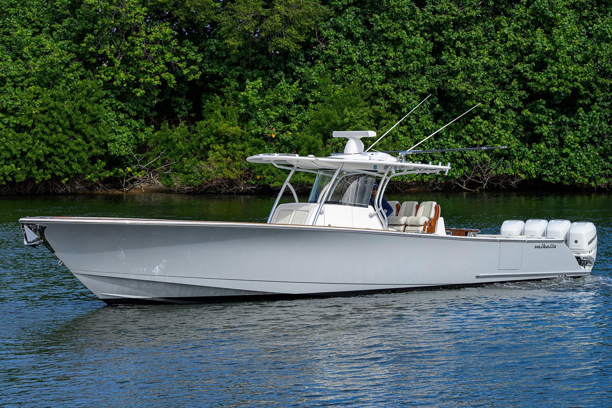 2021 Valhalla Boatworks V-41 cruising on a serene waterway, surrounded by lush greenery.