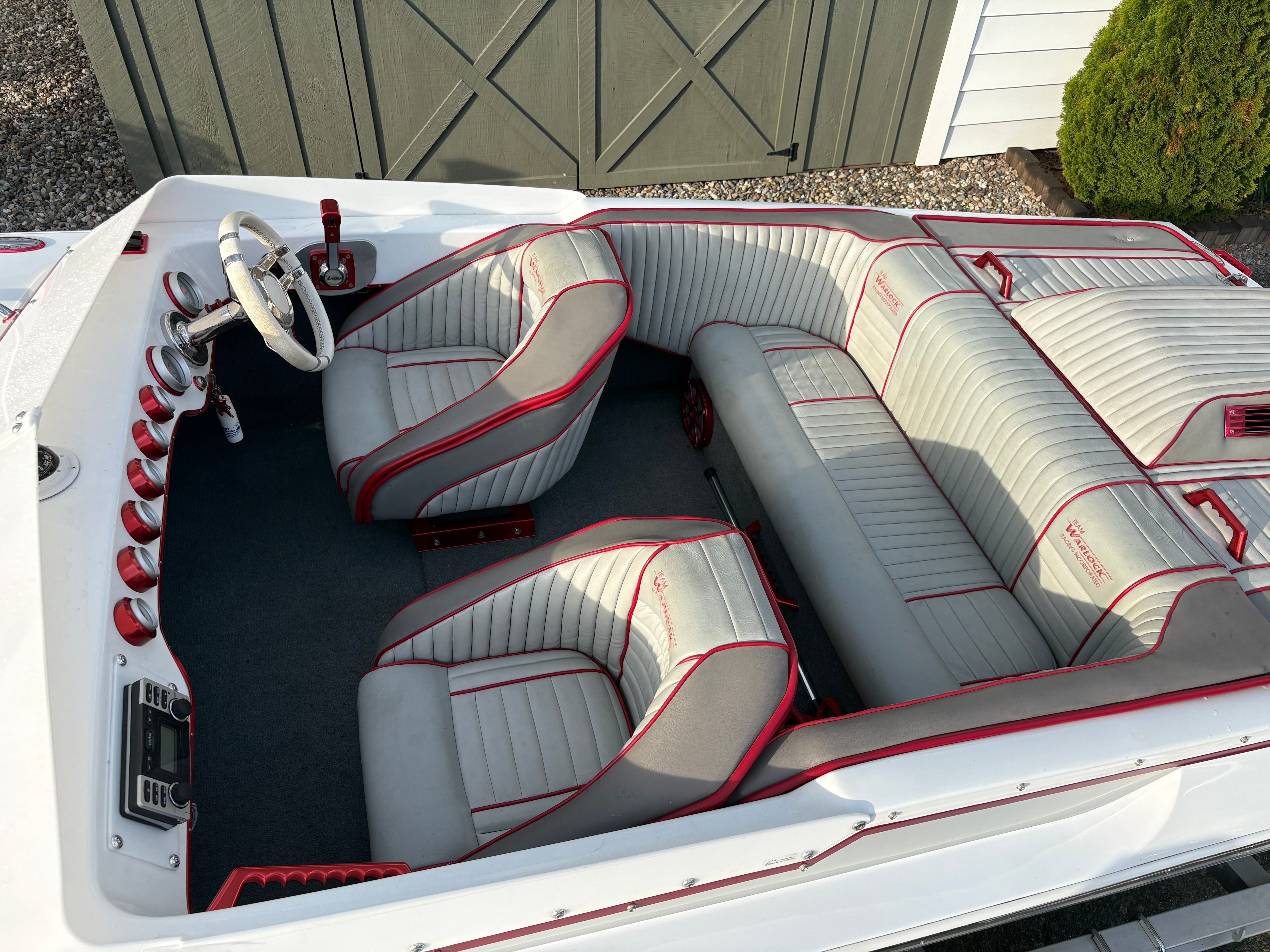 Interior of a 1986 Warlock 23 boat with gray and red seating.