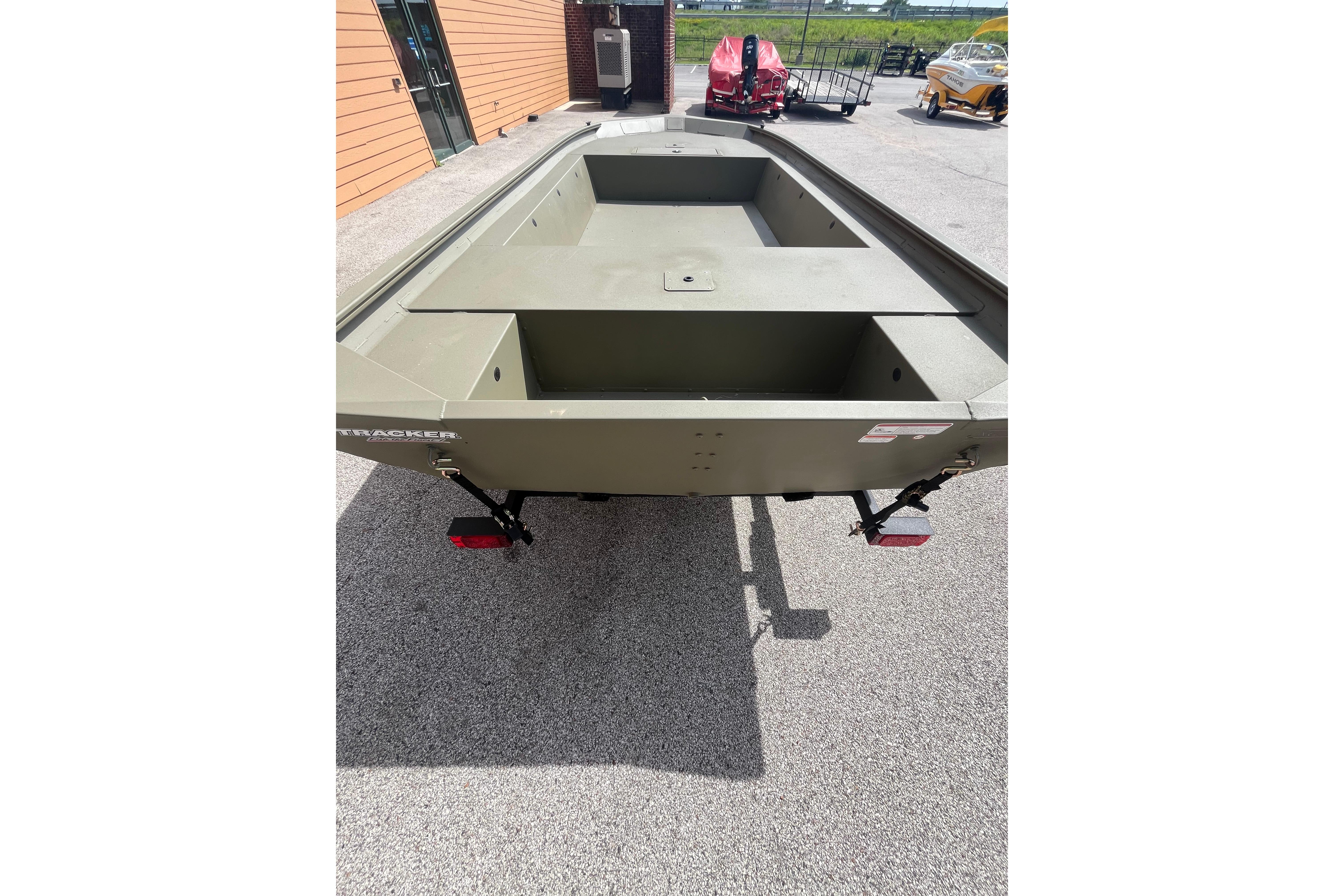 2026 Tracker Grizzly 1754 Utility boat on pavement, showcasing spacious interior design.
