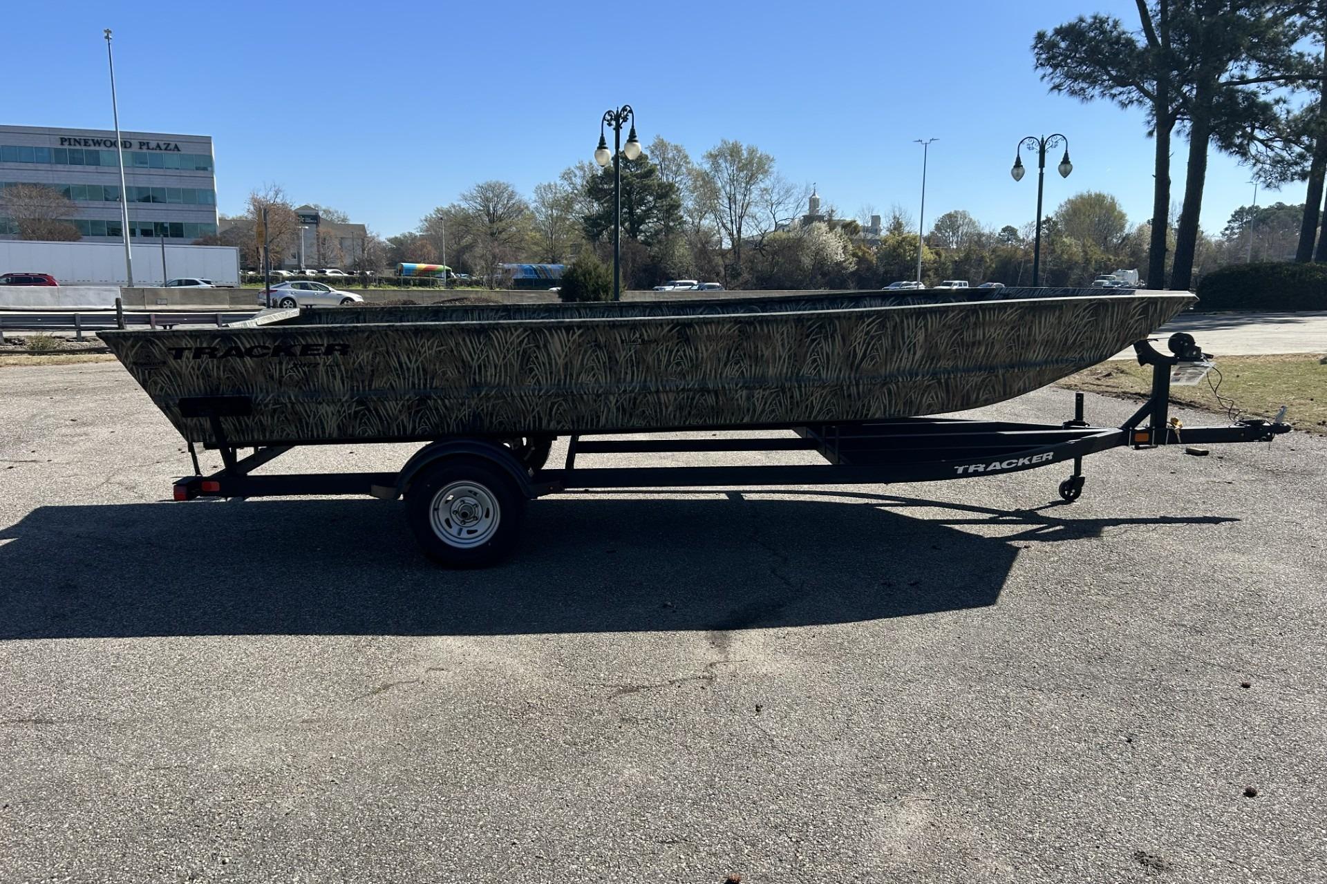 2025 Tracker Grizzly 2072 Utility boat on trailer in parking lot.