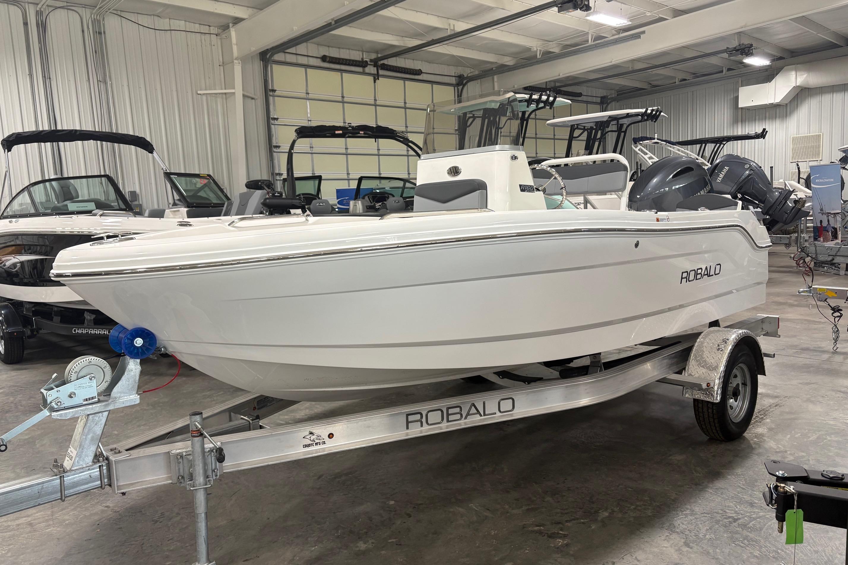 2026 Robalo R160 Center Console boat on trailer in indoor showroom.
