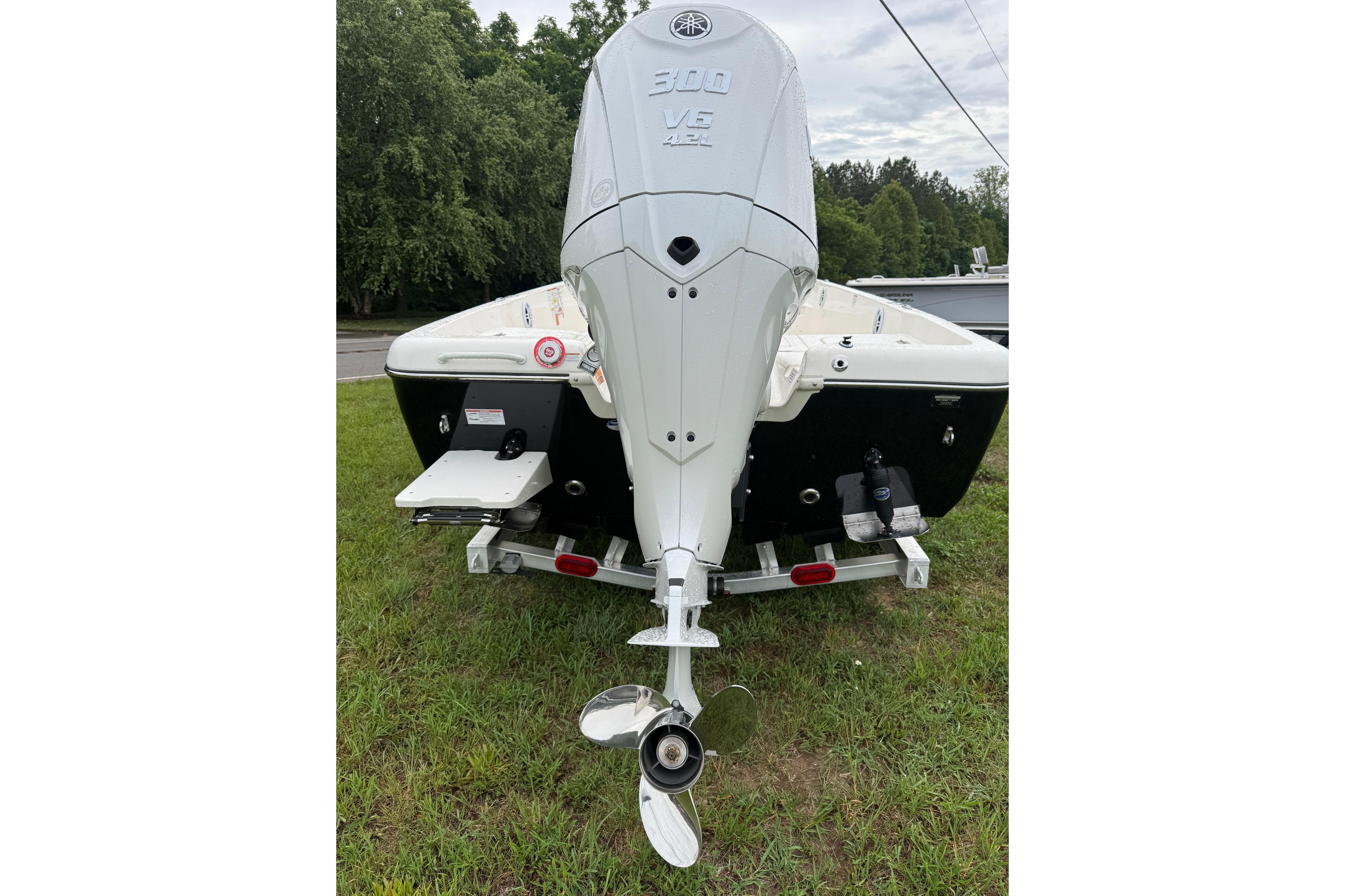 2026 Skeeter SX2350 boat with powerful outboard motor, parked on grass.