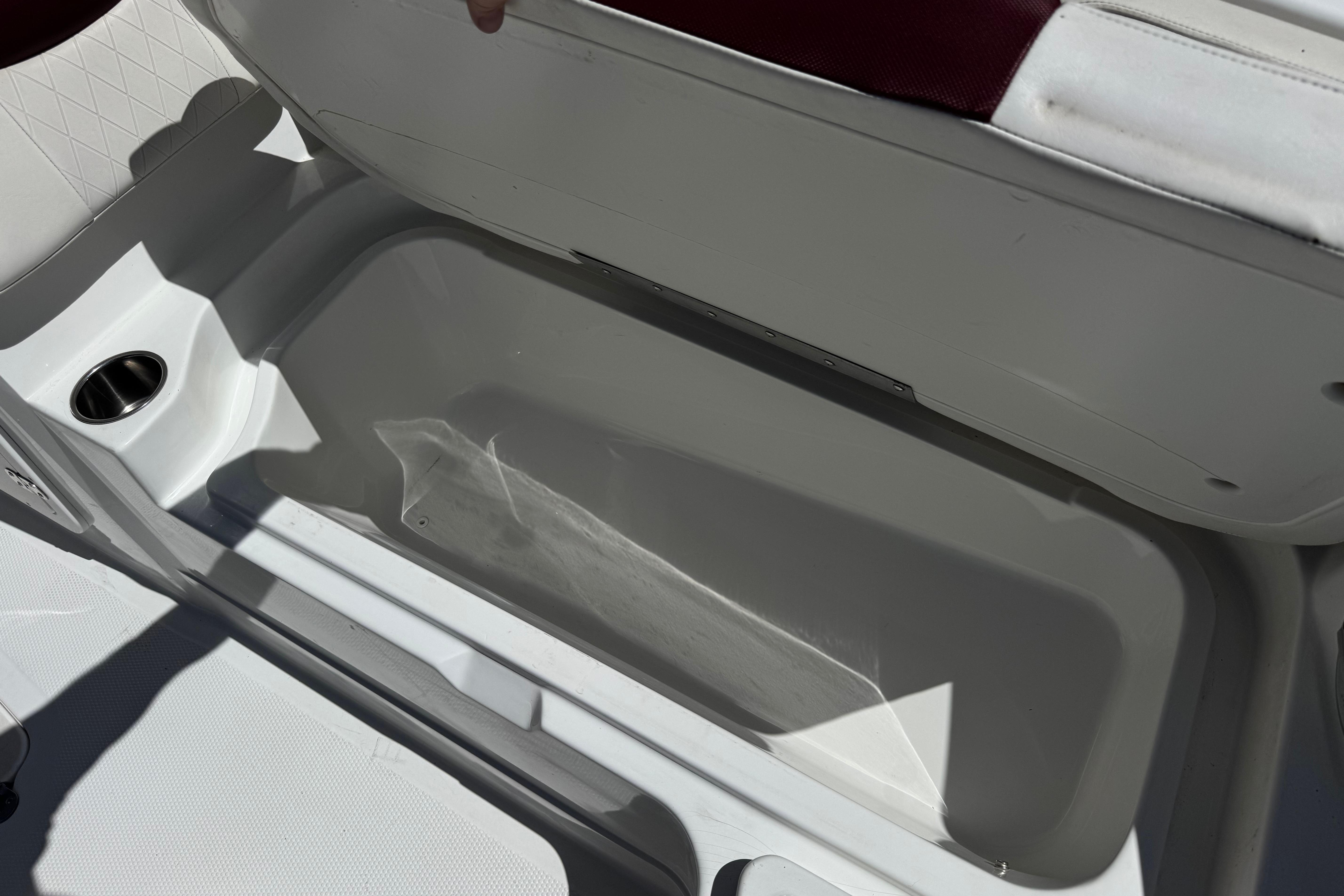Open storage compartment in a 2017 Tahoe 2150 boat, featuring a cup holder.
