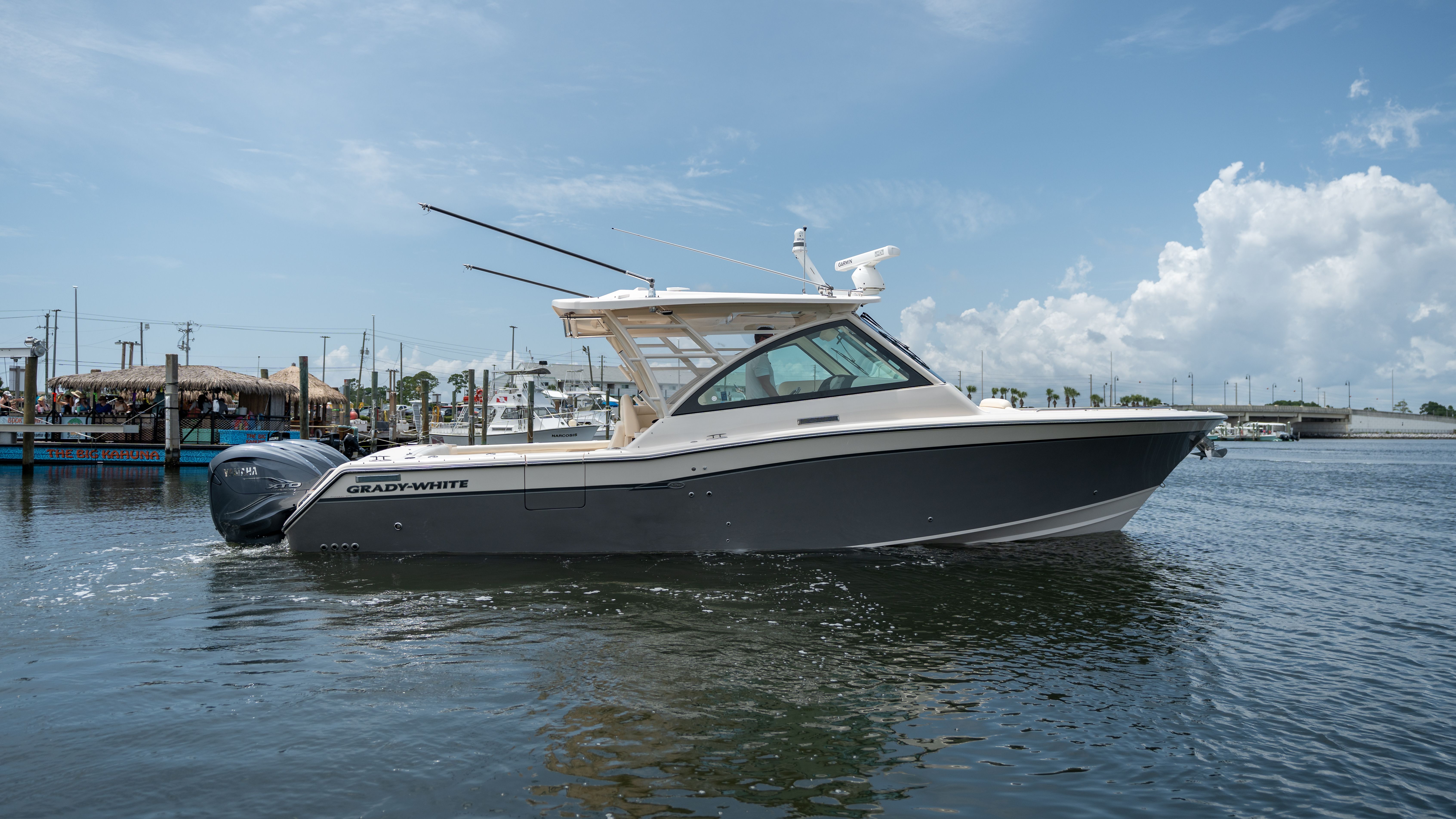 2019 Grady-White 375 Freedom on calm water in a harbor, with clear skies in the background.