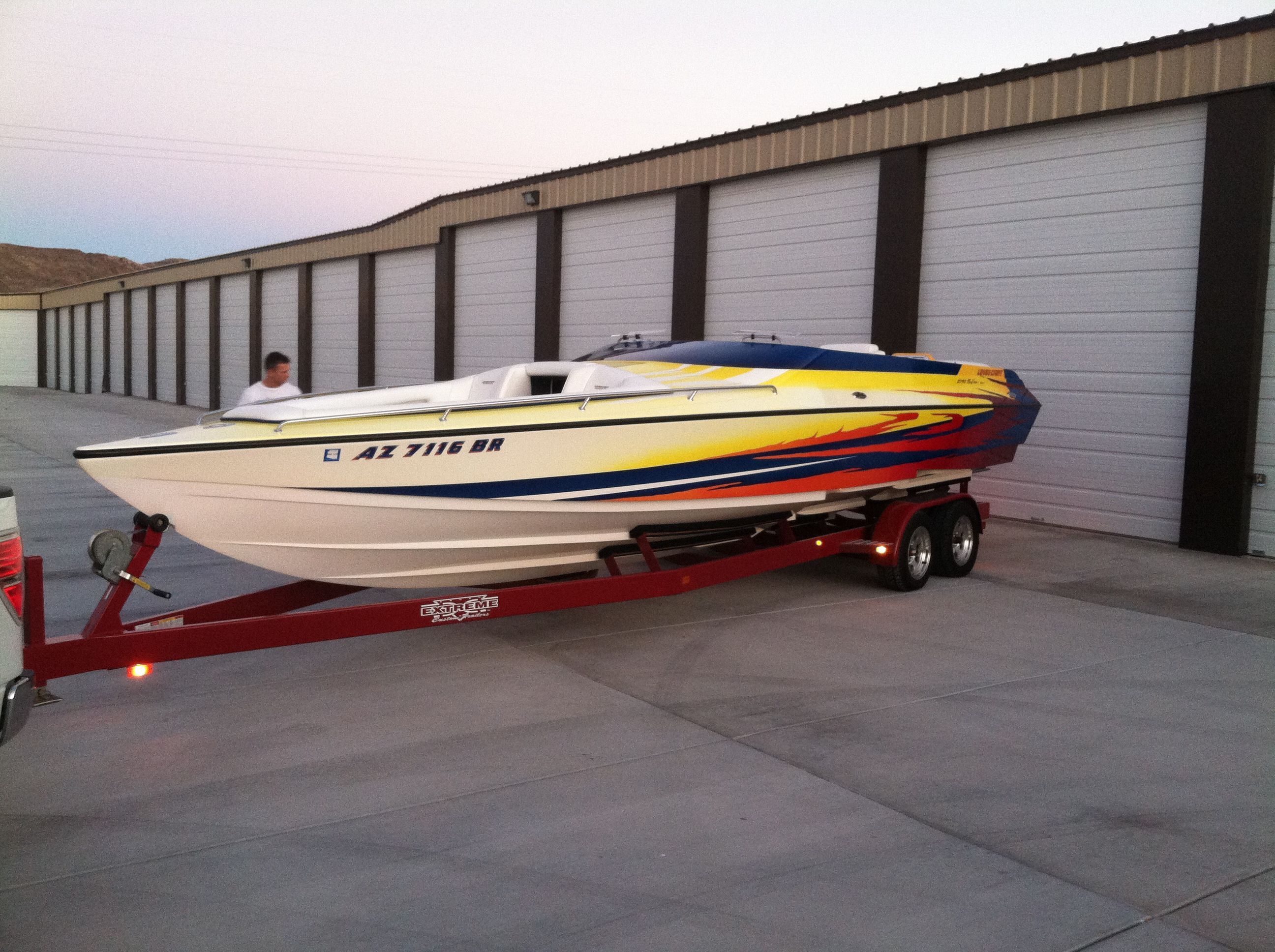 2002 Lavey Craft 2750 NUERA boat on trailer in front of garages.
