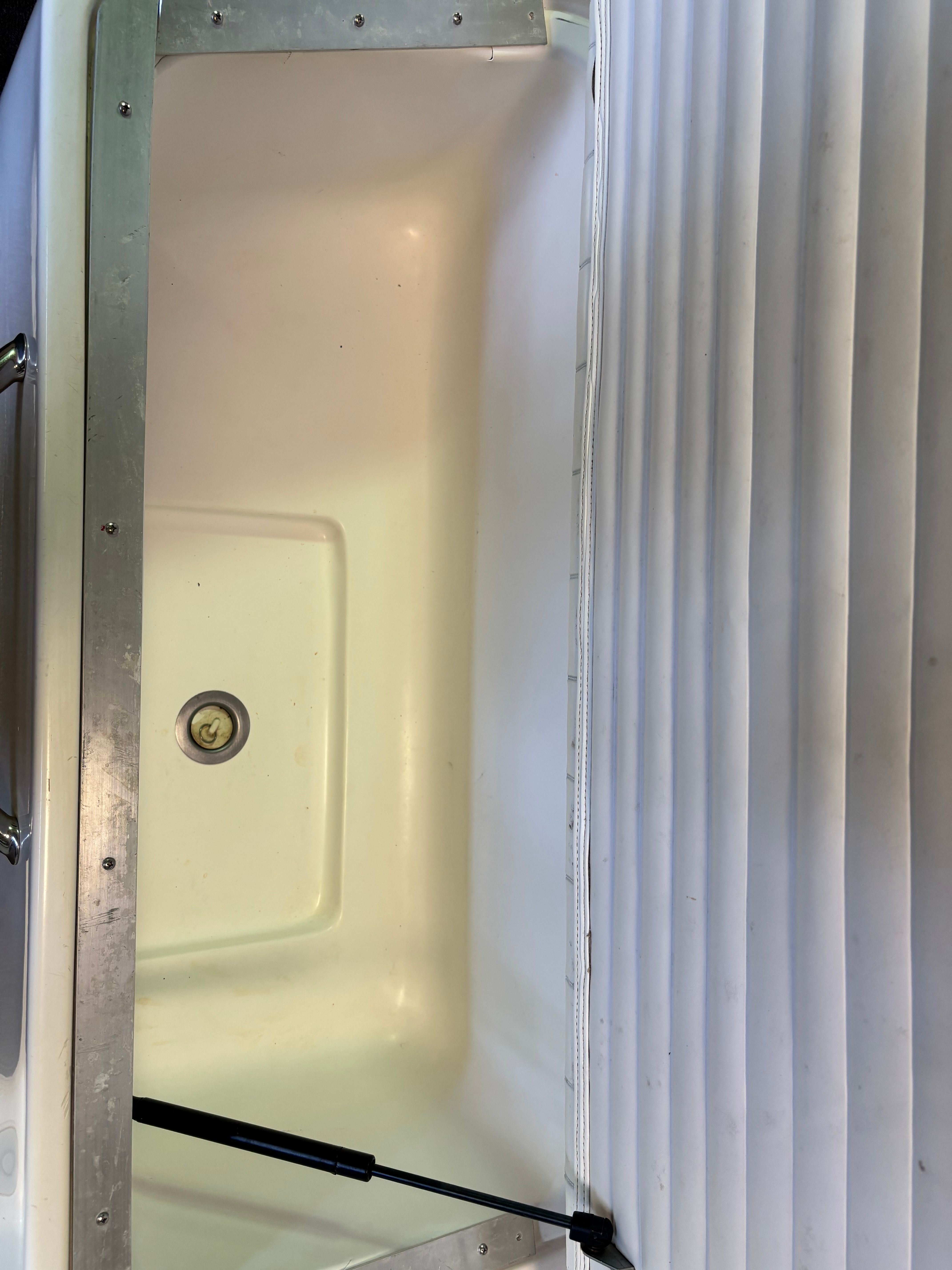 A view of the storage compartment in a 2006 Regal 2200 Bowrider with white upholstery.