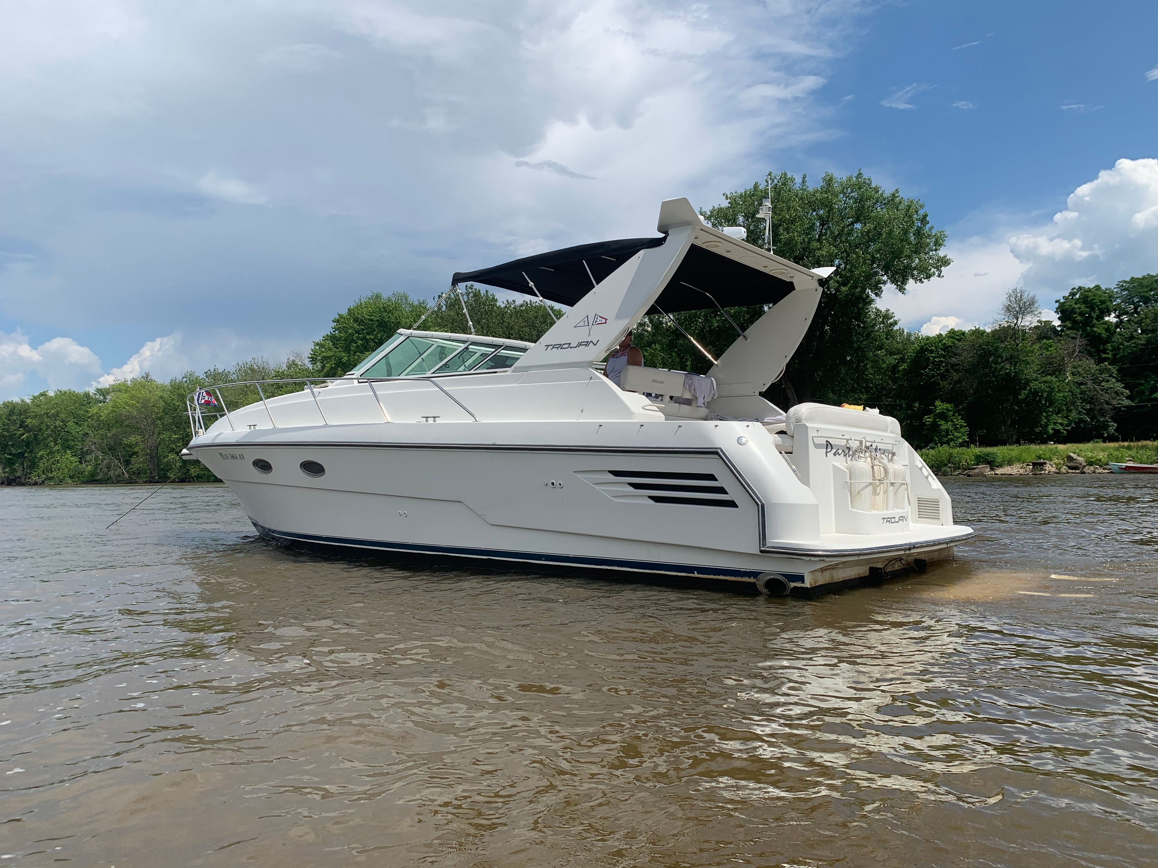 1995 Trojan 390x on calm water with trees in the background.