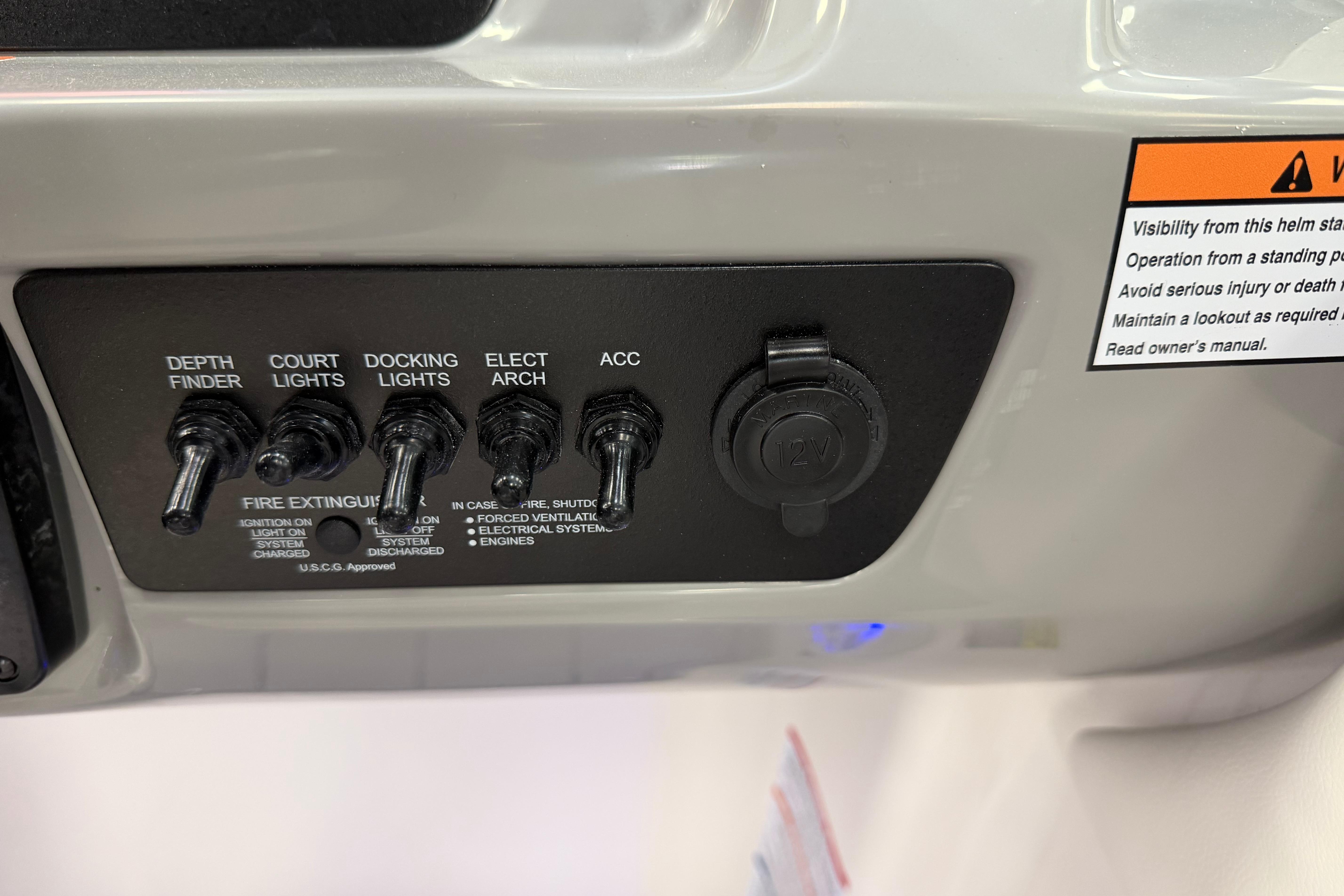 Control panel of 2025 Chaparral 21 SSi OB boat with switches and warning label.