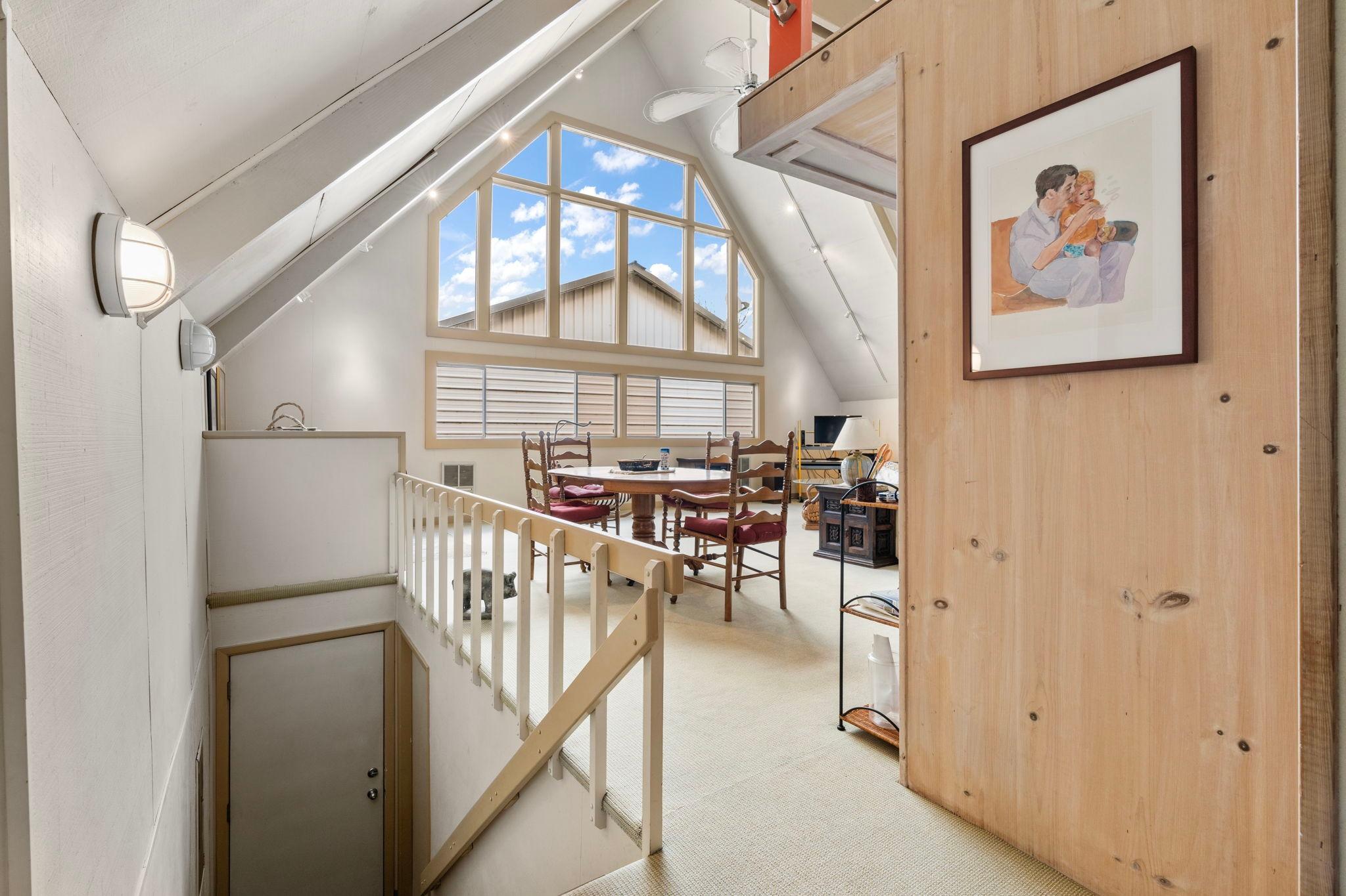A-frame boathouse interior with large windows, wooden accents, and cozy dining area, built in 1976.