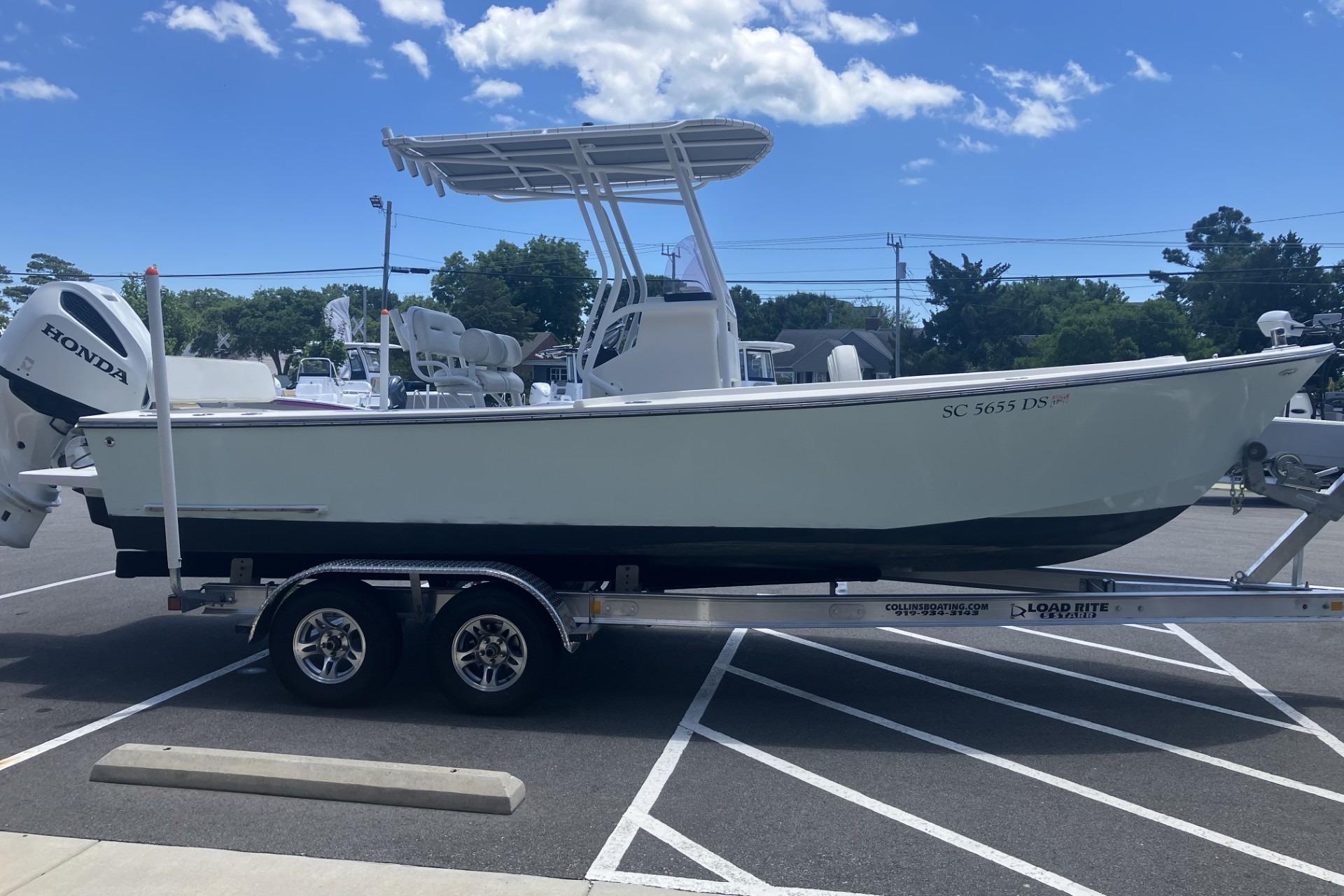 2022 May-Craft 2300 CCX boat on trailer in parking lot, sunny day.