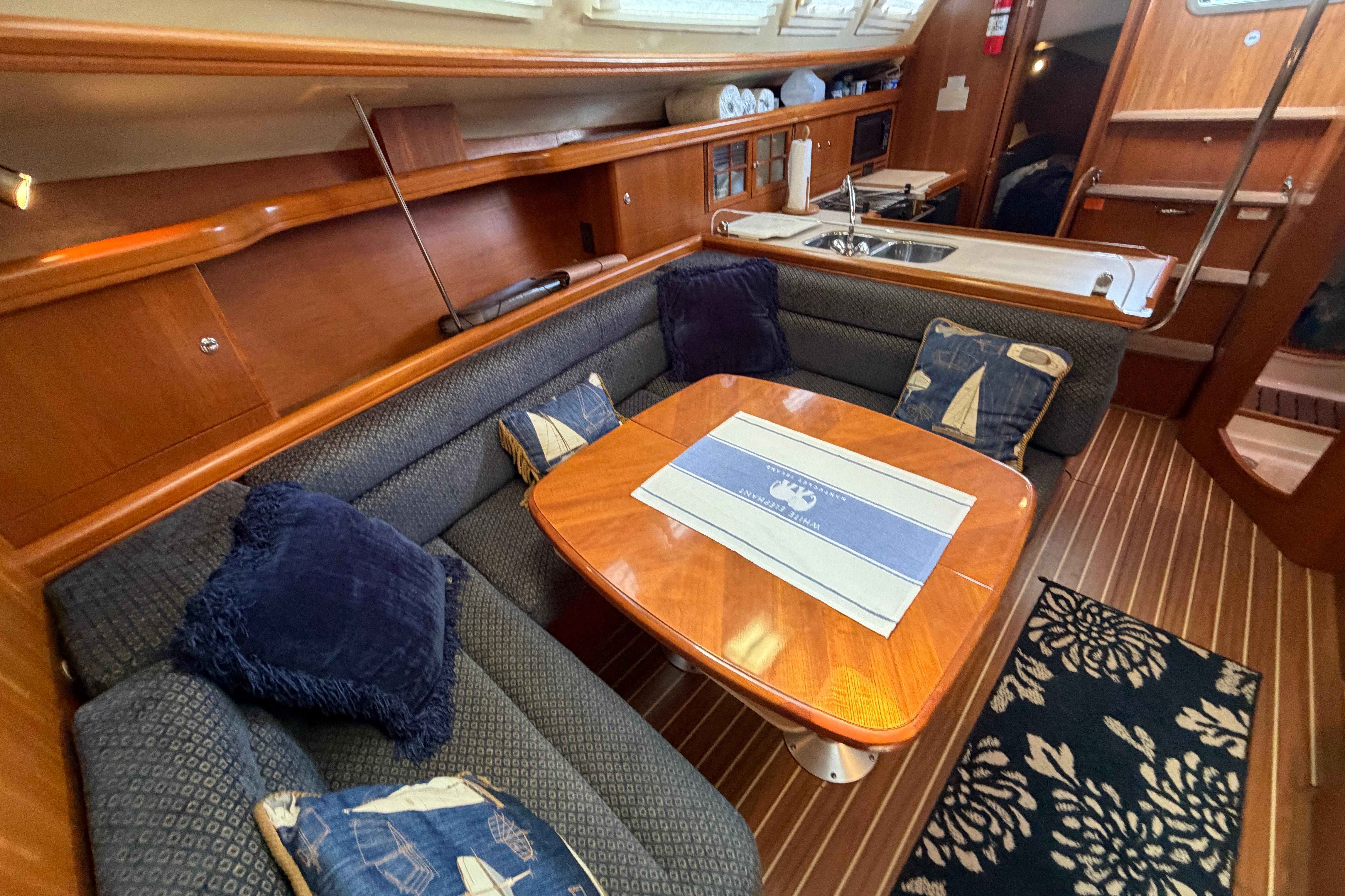 Luxurious interior of a 2005 Hunter 38 yacht with elegant wood finishes and cozy seating.